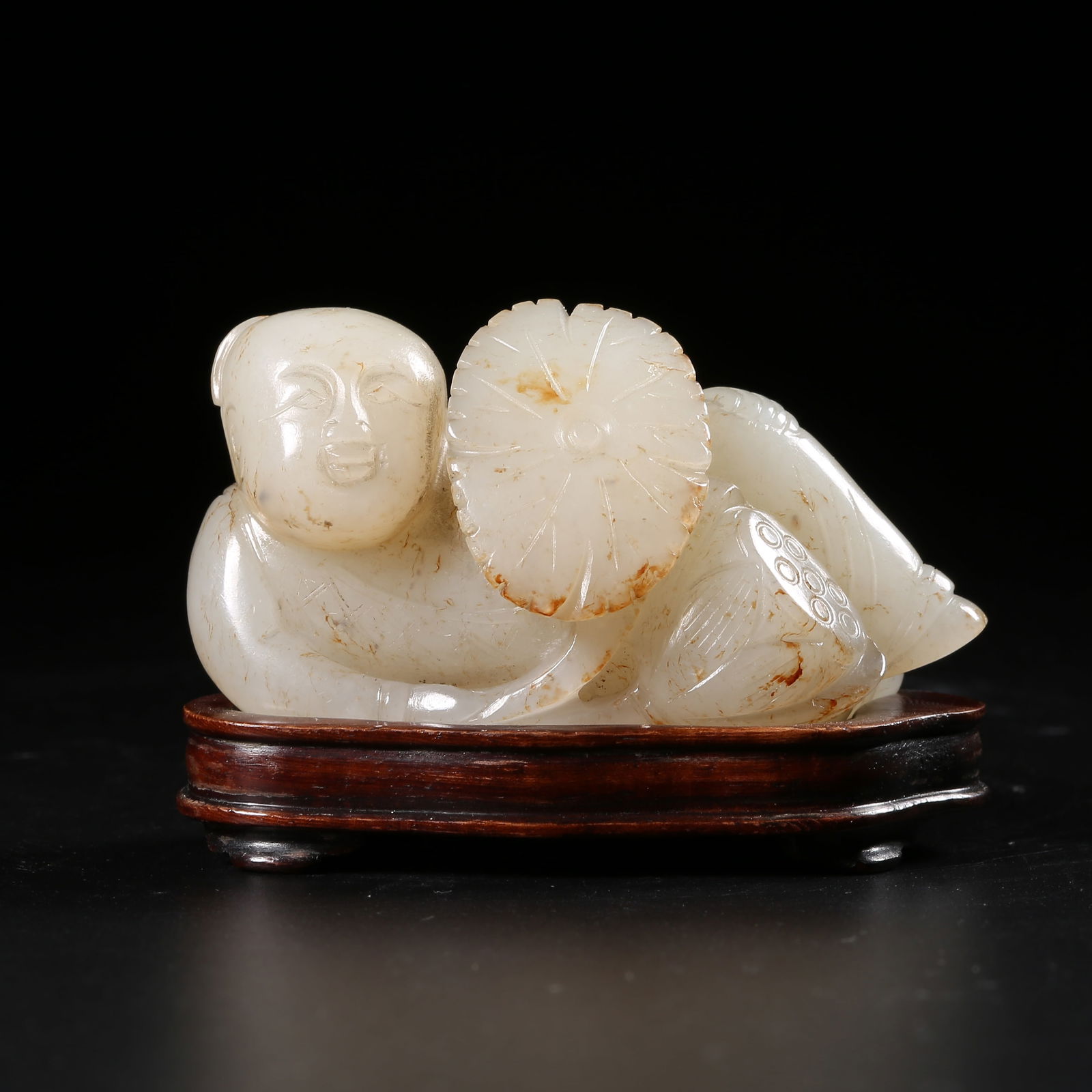 A HETIAN WHITE JADE BOY HOLDING A LOTUS ORNAMENT: Hetian white jade boy holding a lotus ornament