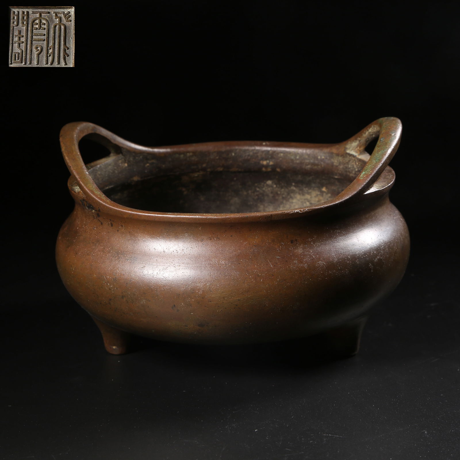 A BRONZE TRIPOD CENSER WITH LOOPED HANDLES: Bronze tripod censer with looped handles