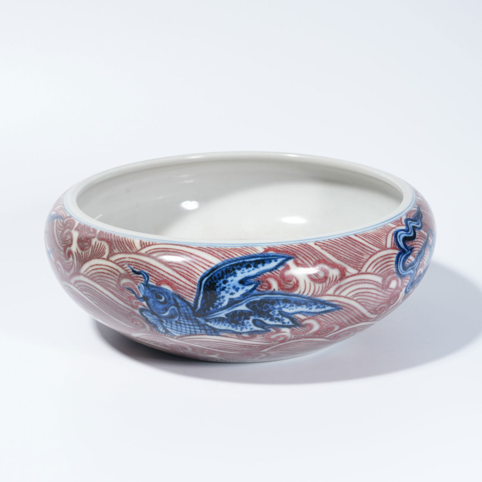 A BLUE-AND-WHITE UNDERGLAZE-RED WASH BASIN WITH BEAST MOTIF: Blue-and-white underglaze-red wash basin with beast motif