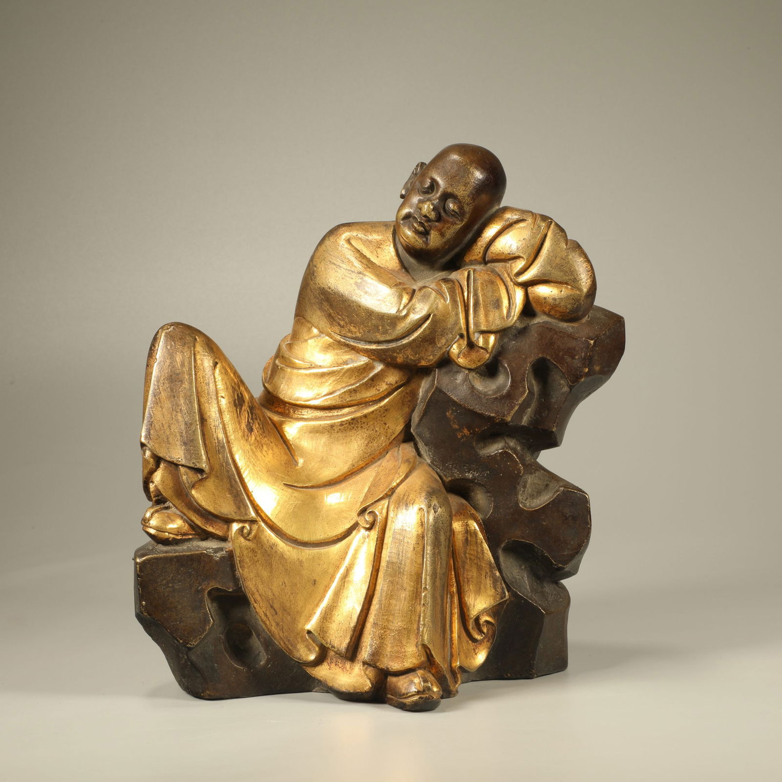A GILT-BRONZE RECLINING ARHAT FIGURE (1 of 6)