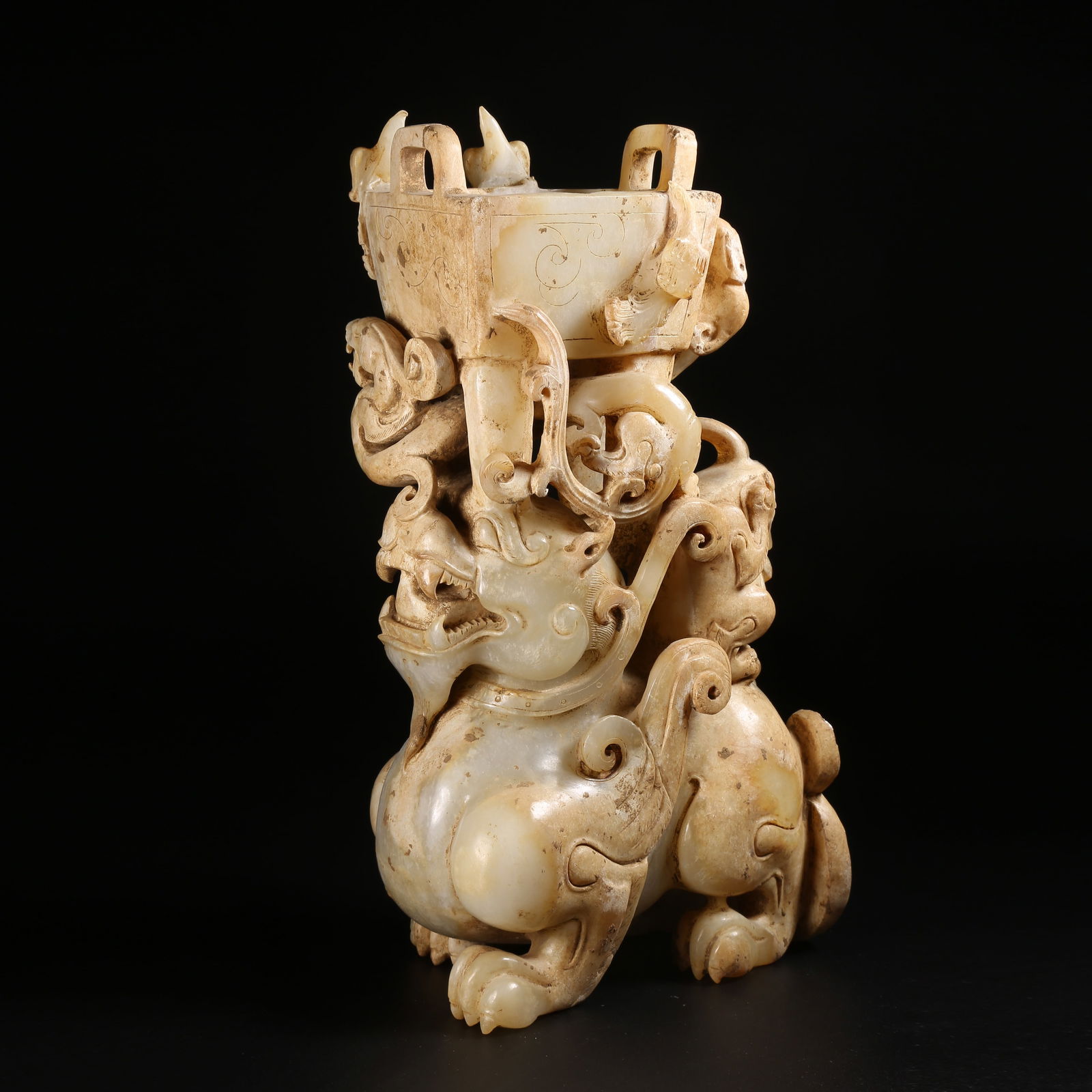 A ARCHAIC JADE ORNAMENT OF AN AUSPICIOUS BEAST CARRYING A DING: Archaic jade ornament of an auspicious beast carrying a ding