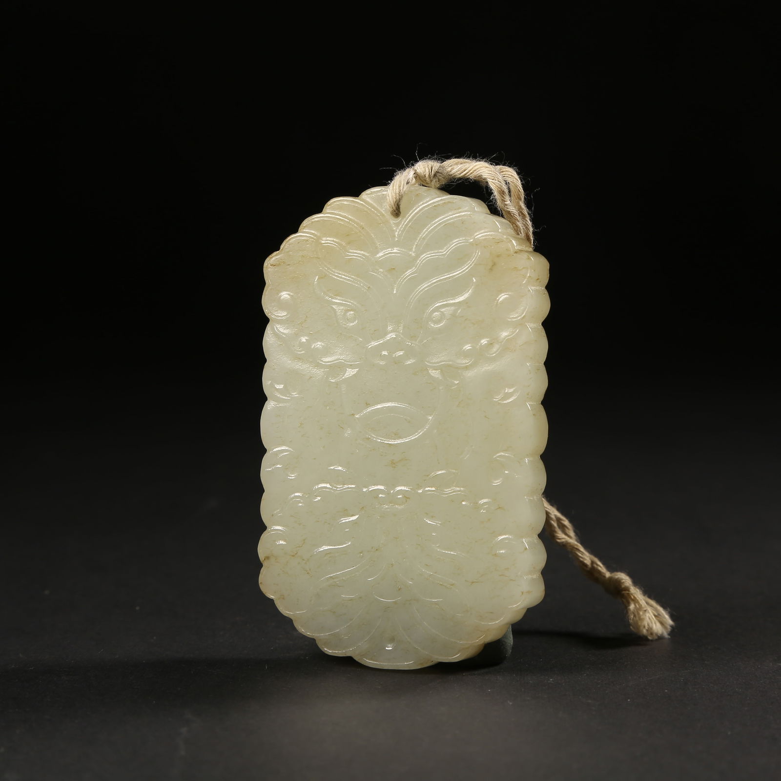 A HETIAN JADE PENDANT WITH FUSHOU (MASK-HEAD) MOTIF (1 of 7)