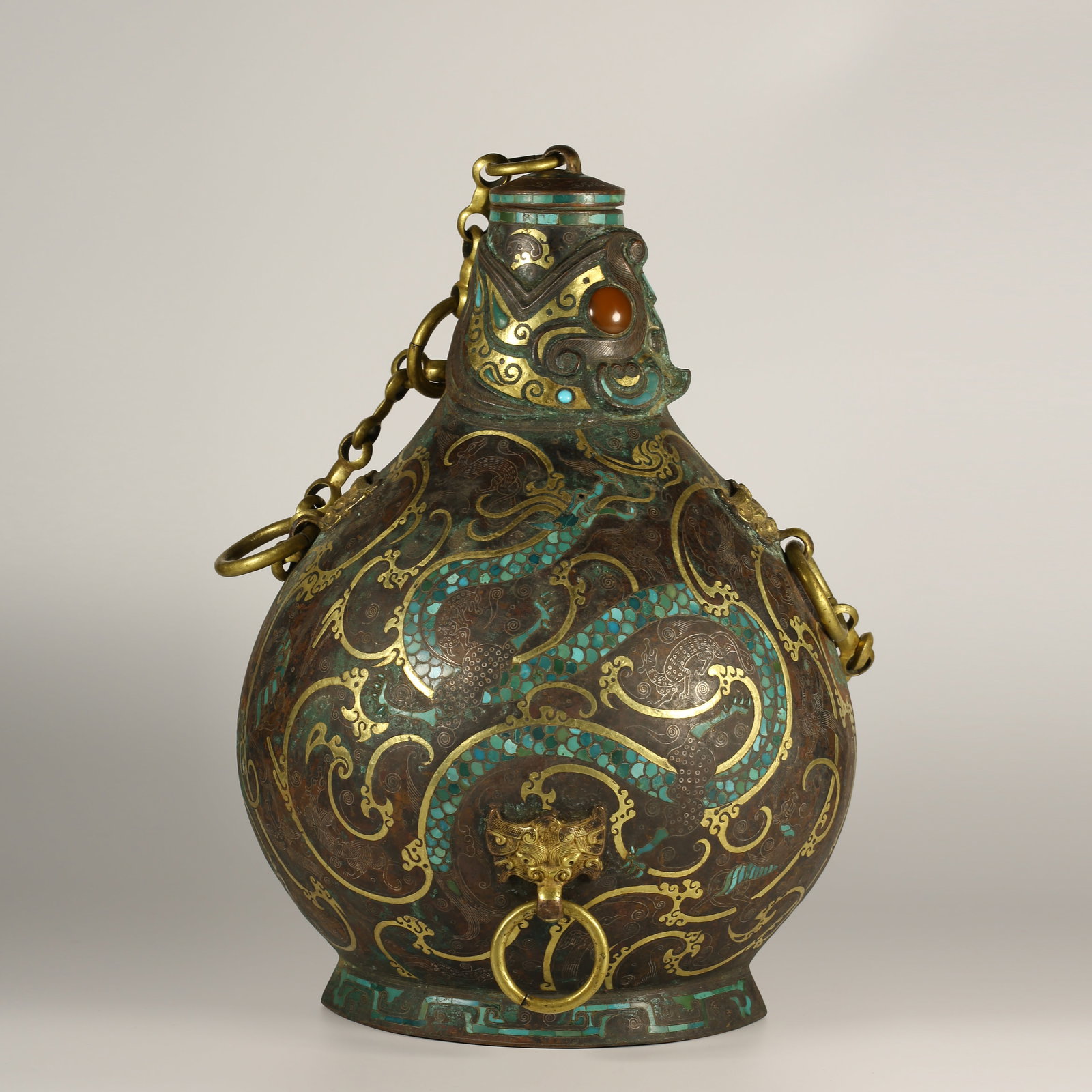 A BRONZE VESSEL WITH GOLD-AND-SILVER INLAY, TURQUOISE, AND BEAST-HEAD RING HANDLE: Bronze Vessel with Gold-and-Silver Inlay, Turquoise, and Beast-Head Ring Handle