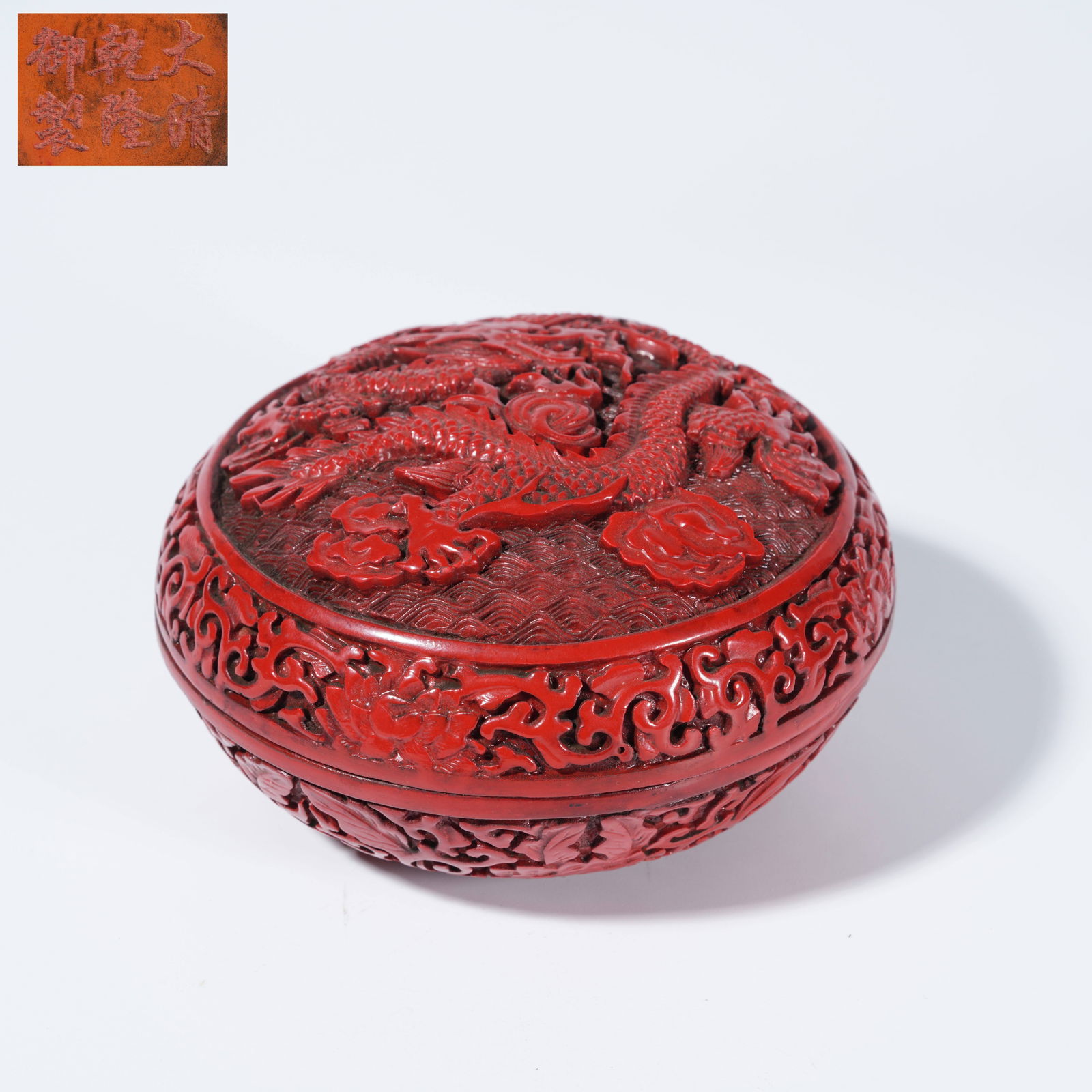 A CARVED RED LACQUER LIDDED BOX WITH CLOUD AND DRAGON MOTIFS (1 of 9)