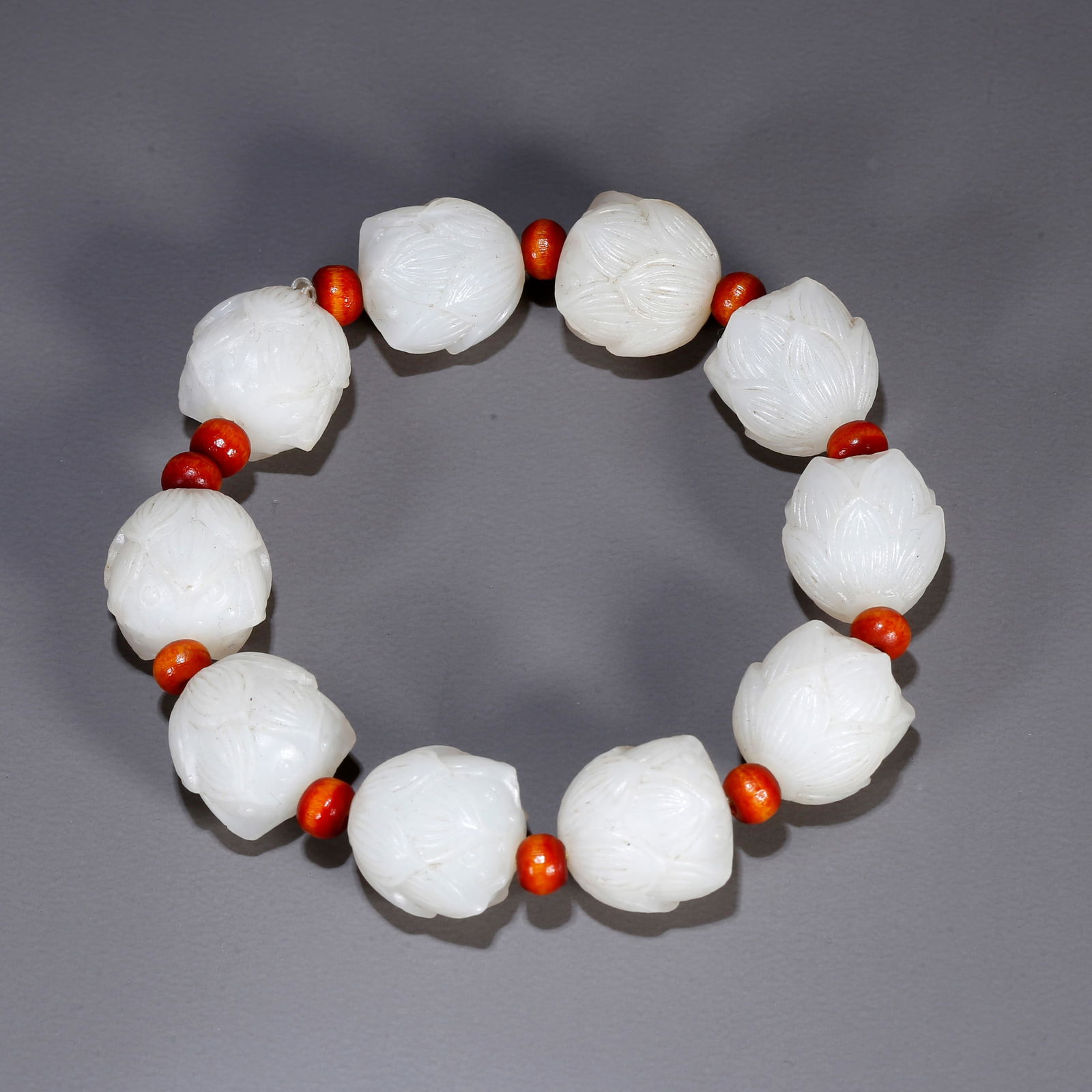 A HETIAN JADE BRACELET CARVED WITH LOTUS MOTIF (1 of 9)