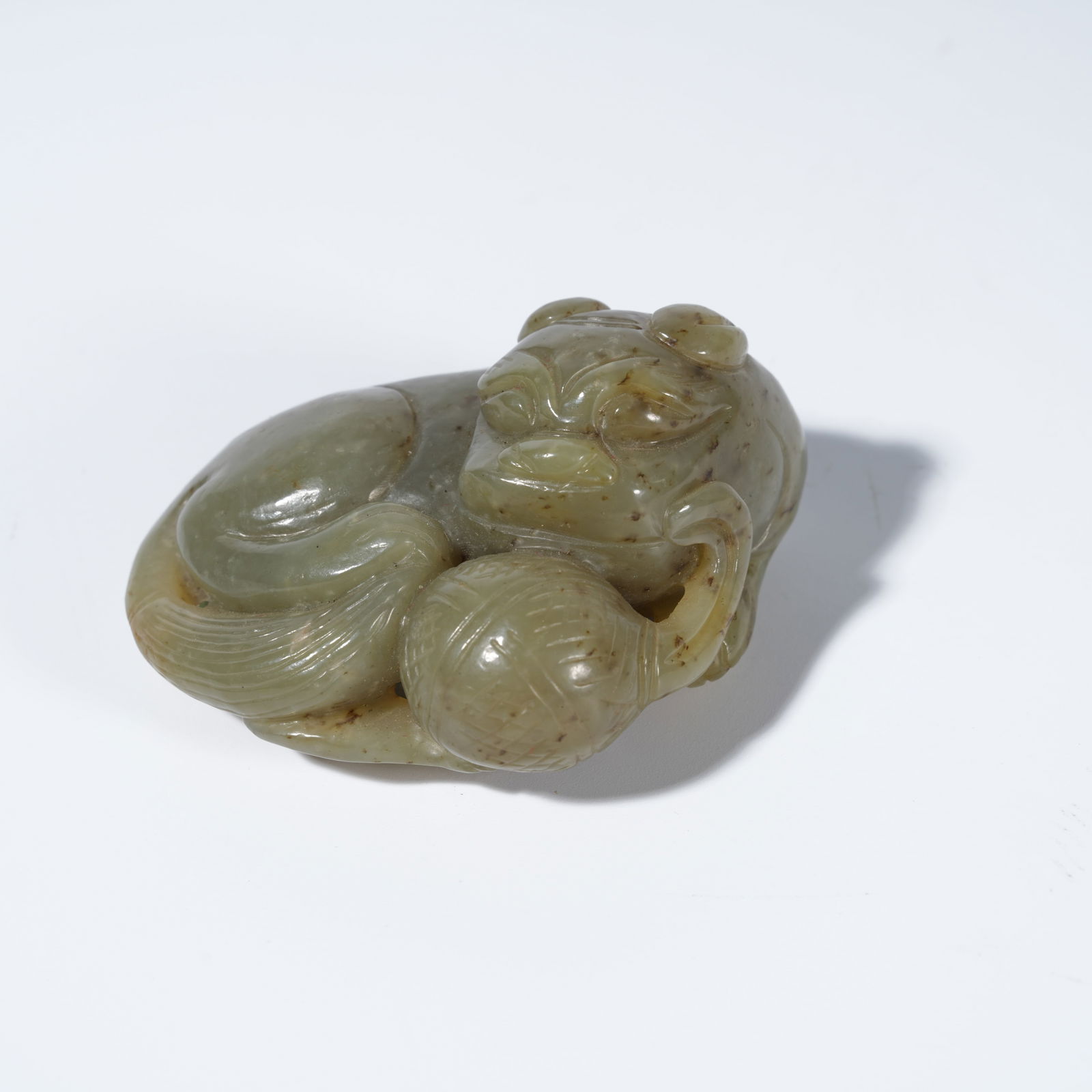 A HETIAN JADE CARVED LION PLAYING WITH A BROCADE BALL FIGURE (1 of 9)
