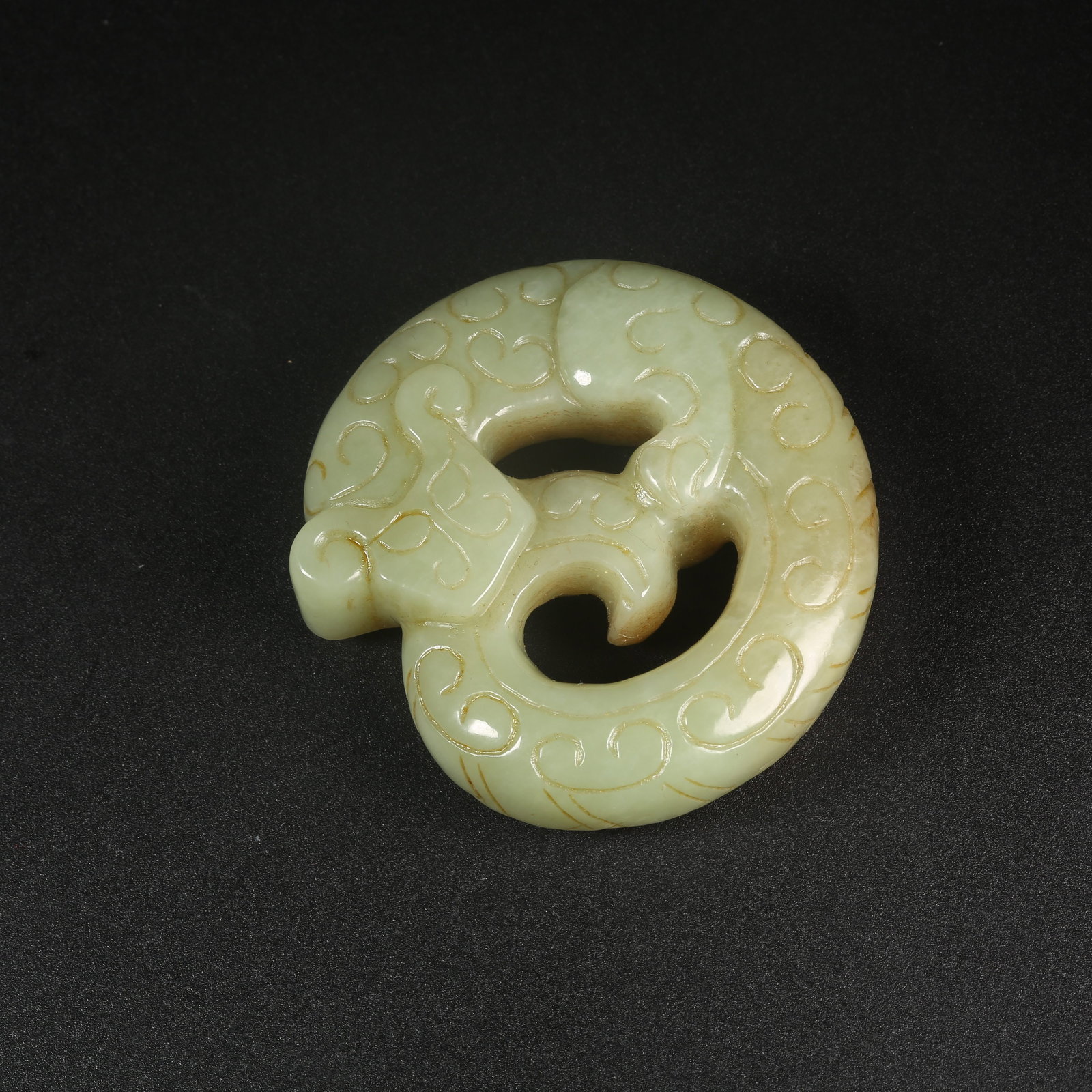A ARCHAIC JADE PENDANT OF A DRAGON BITING ITS TAIL (1 of 9)