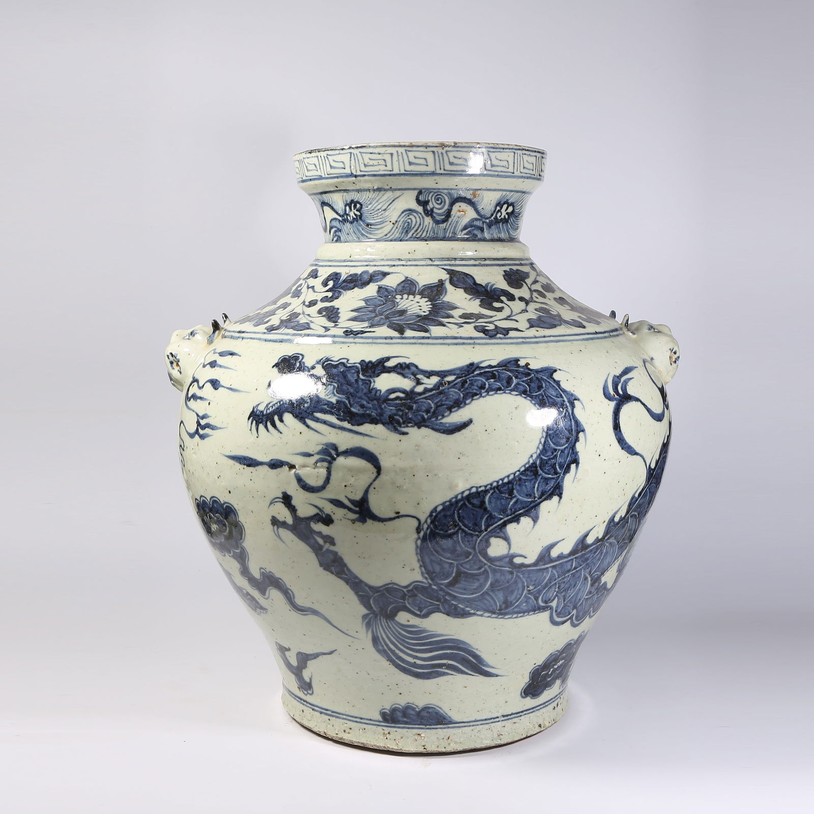 A BLUE-AND-WHITE VASE WITH CLOUD AND DRAGON MOTIFS AND MASK HANDLES: Blue-and-White Vase with Cloud and Dragon Motifs and Mask Handles