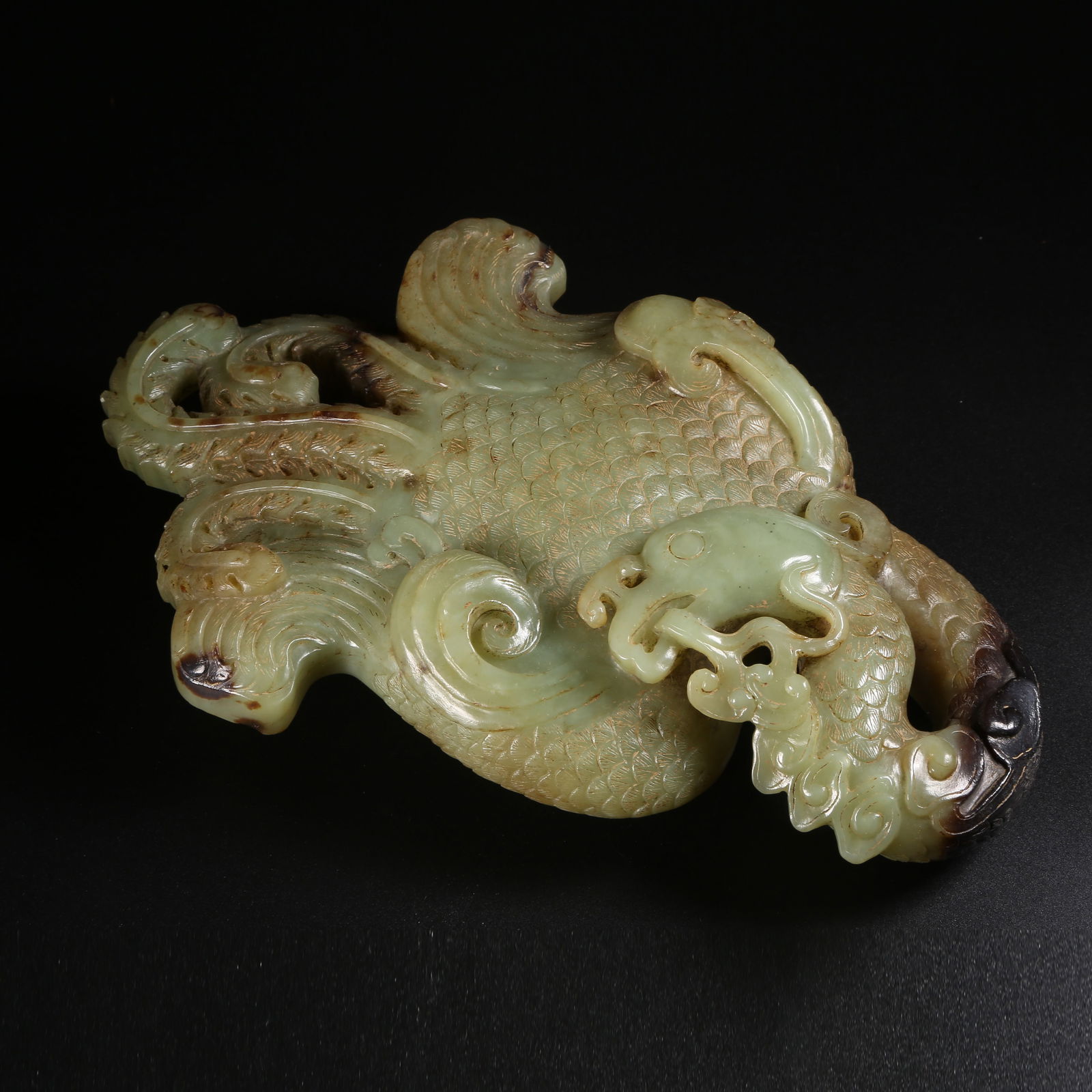 A ARCHAIC JADE ORNAMENT OF A DIVINE PHOENIX HOLDING LINGZHI: Archaic jade ornament of a divine phoenix holding lingzhi