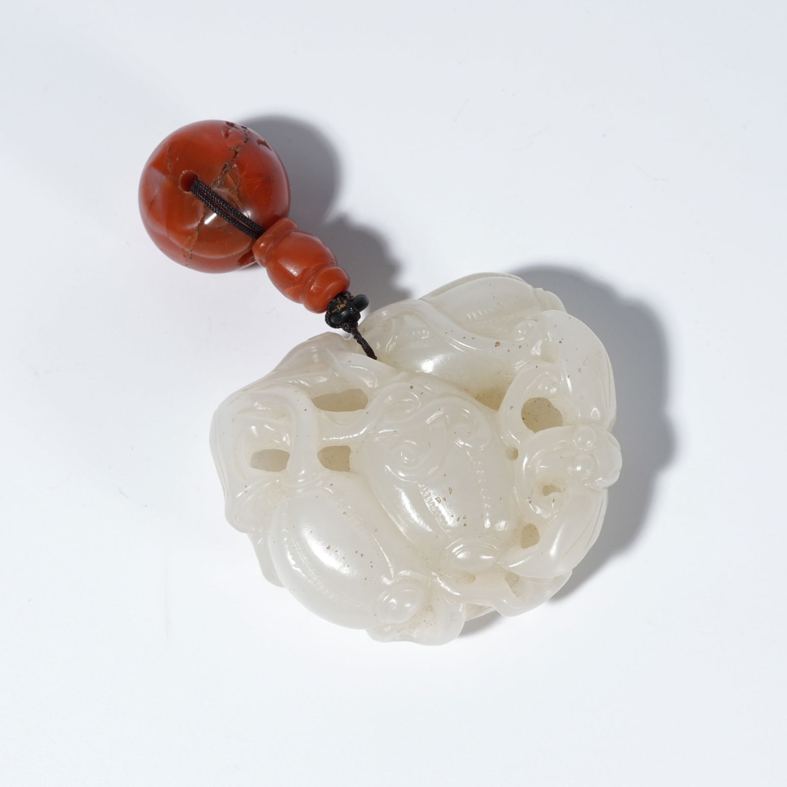 A HETIAN JADE CARVED GOURD-AND-FRUIT MOTIF PENDANT (1 of 10)