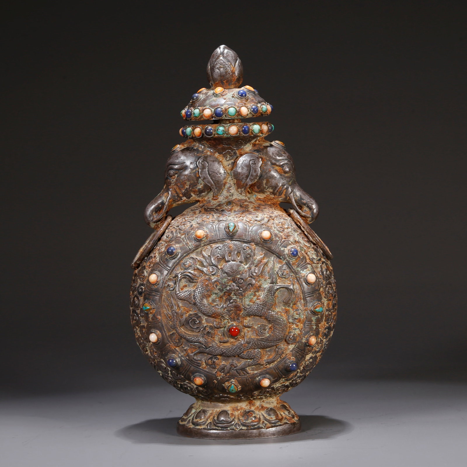 A SILVER LIDDED BOTTLE WITH CLOUD AND DRAGON MOTIF: Silver lidded bottle with cloud and dragon motif