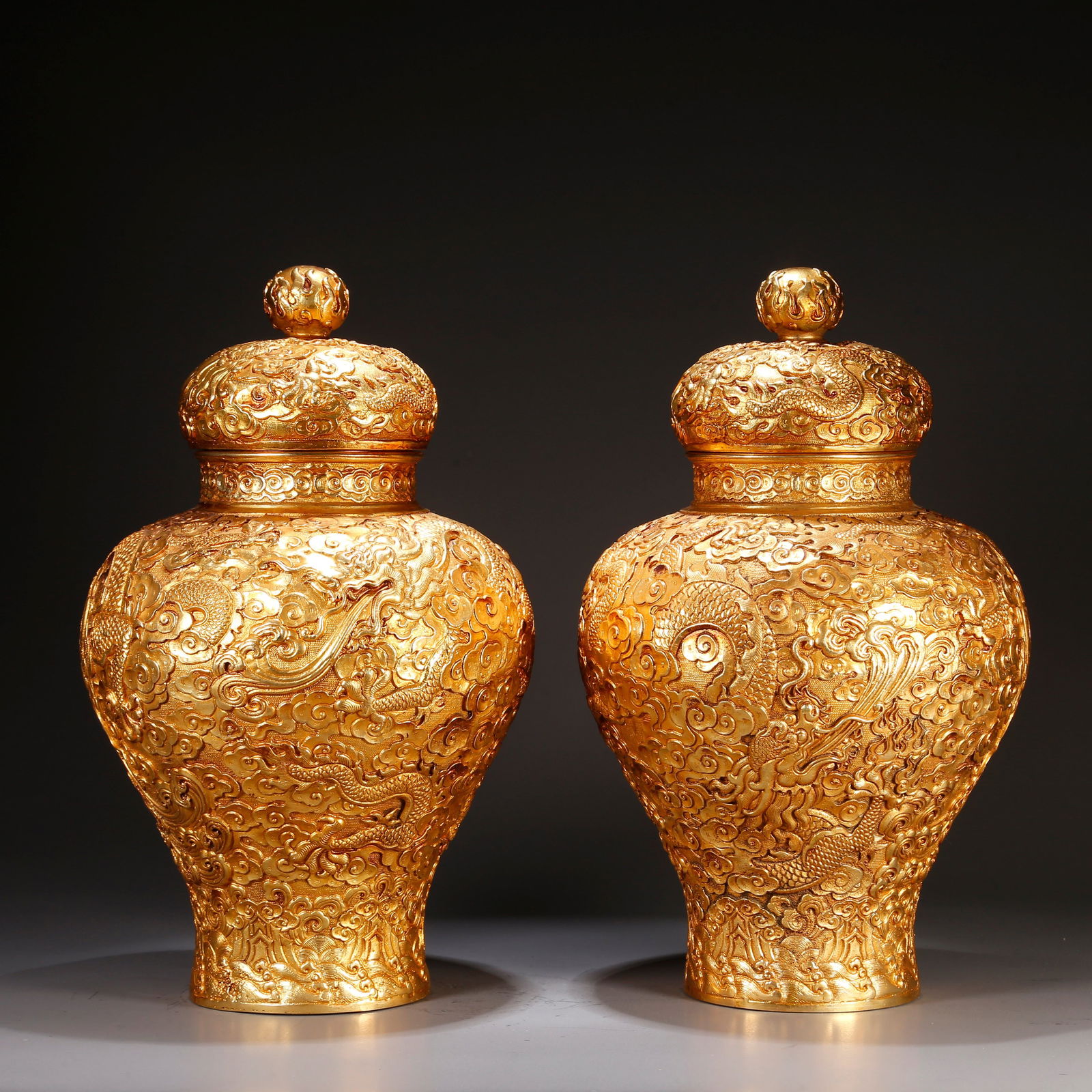 A GILT BRONZE LIDDED JARS WITH CLOUD AND DRAGON MOTIFS (PAIR): Gilt bronze lidded jars with cloud and dragon motifs (pair)
