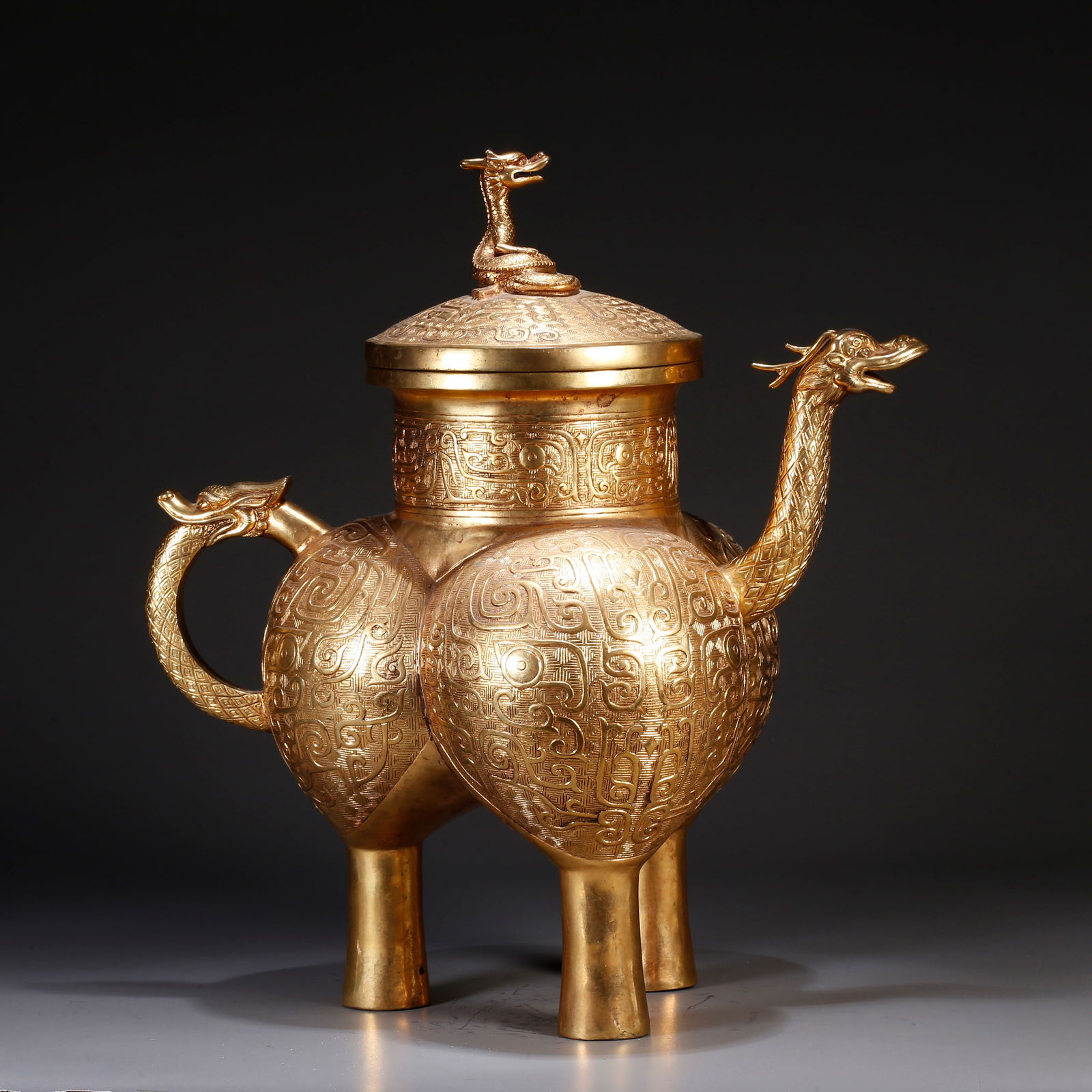A GILT BRONZE EWER WITH BEAST-FACE MOTIF: Gilt bronze ewer with beast-face motif