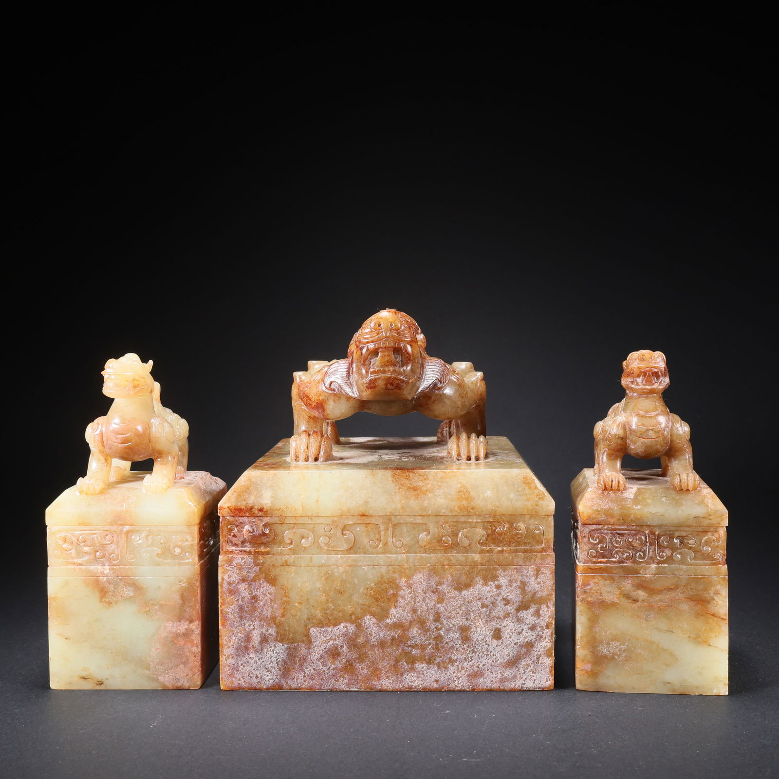 A SET OF THREE HETIAN JADE SEALS WITH BEAST FINIALS: Set of Three Hetian Jade Seals with Beast Finials