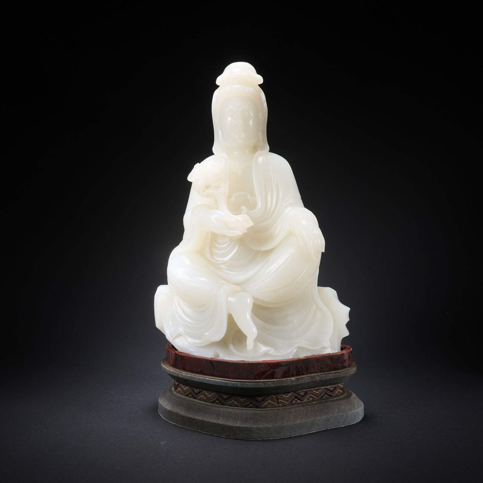 A HETIAN JADE SEATED GUANYIN HOLDING A RUYI ON STAND (1 of 9)
