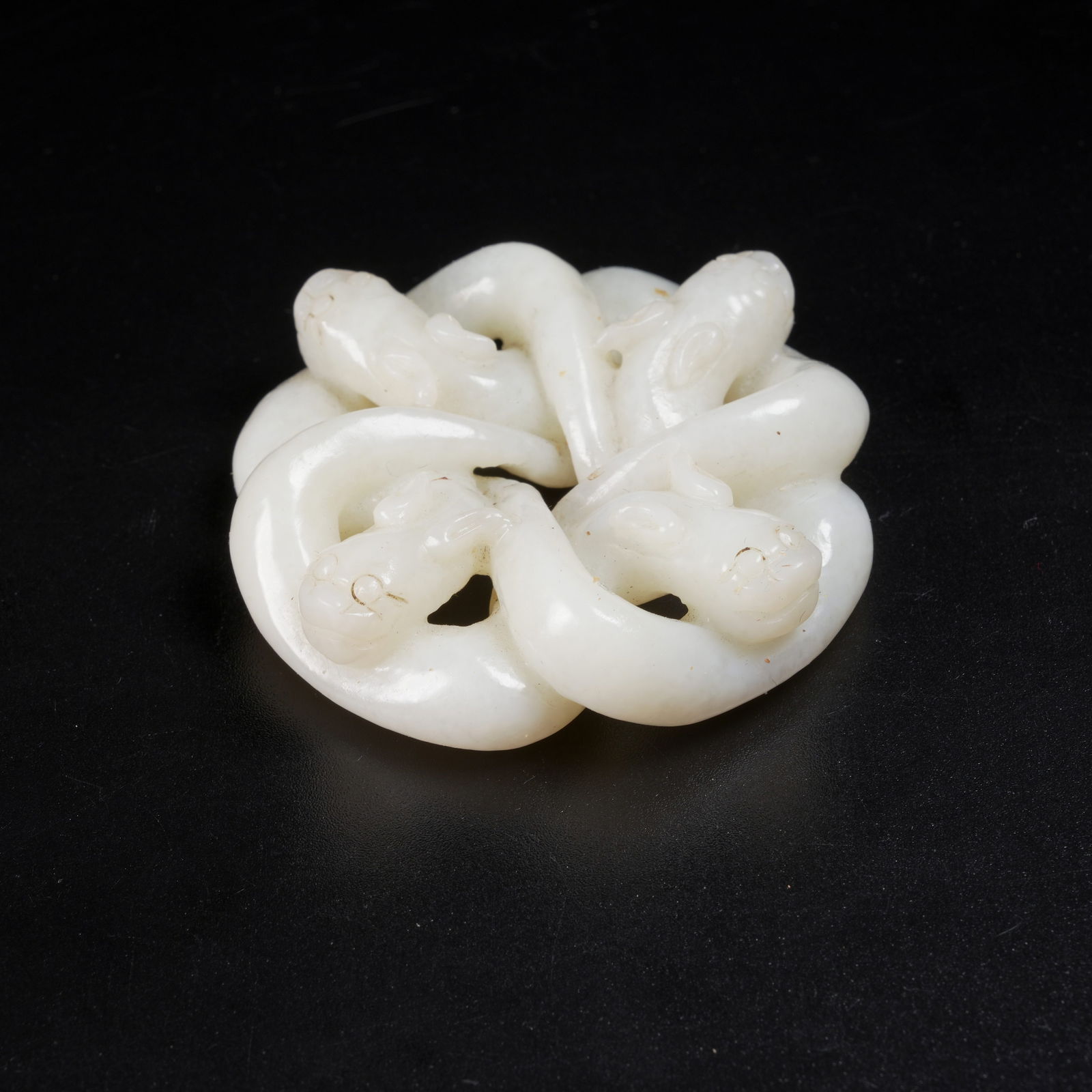 A HETIAN JADE FOUR-DRAGON RING PENDANT: Hetian Jade Four-Dragon Ring Pendant