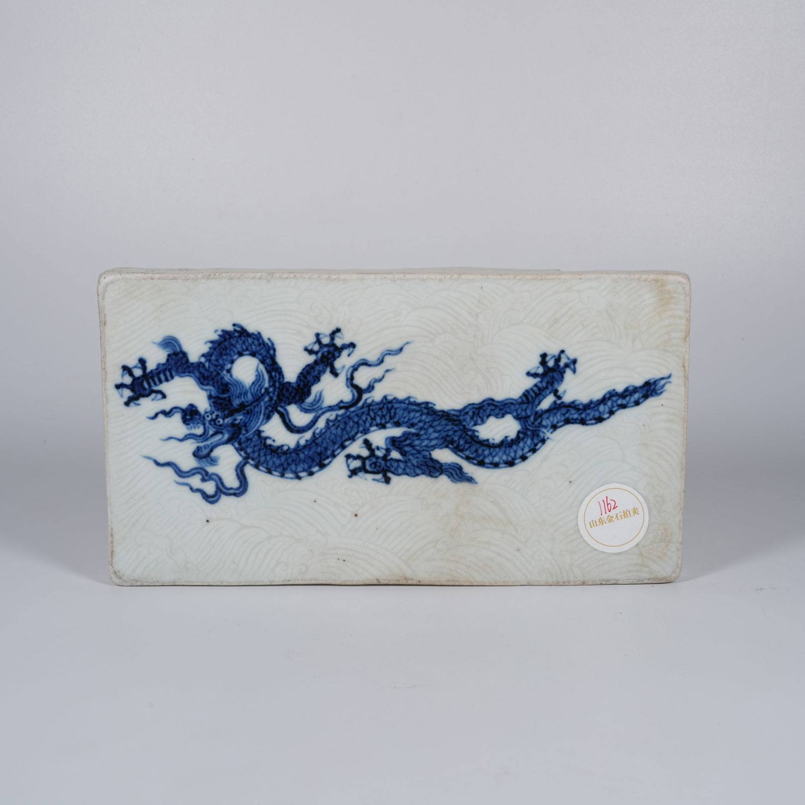 A BLUE-AND-WHITE PORCELAIN PLAQUE WITH SEA-AND-DRAGON MOTIF: Blue-and-white porcelain plaque with sea-and-dragon motif