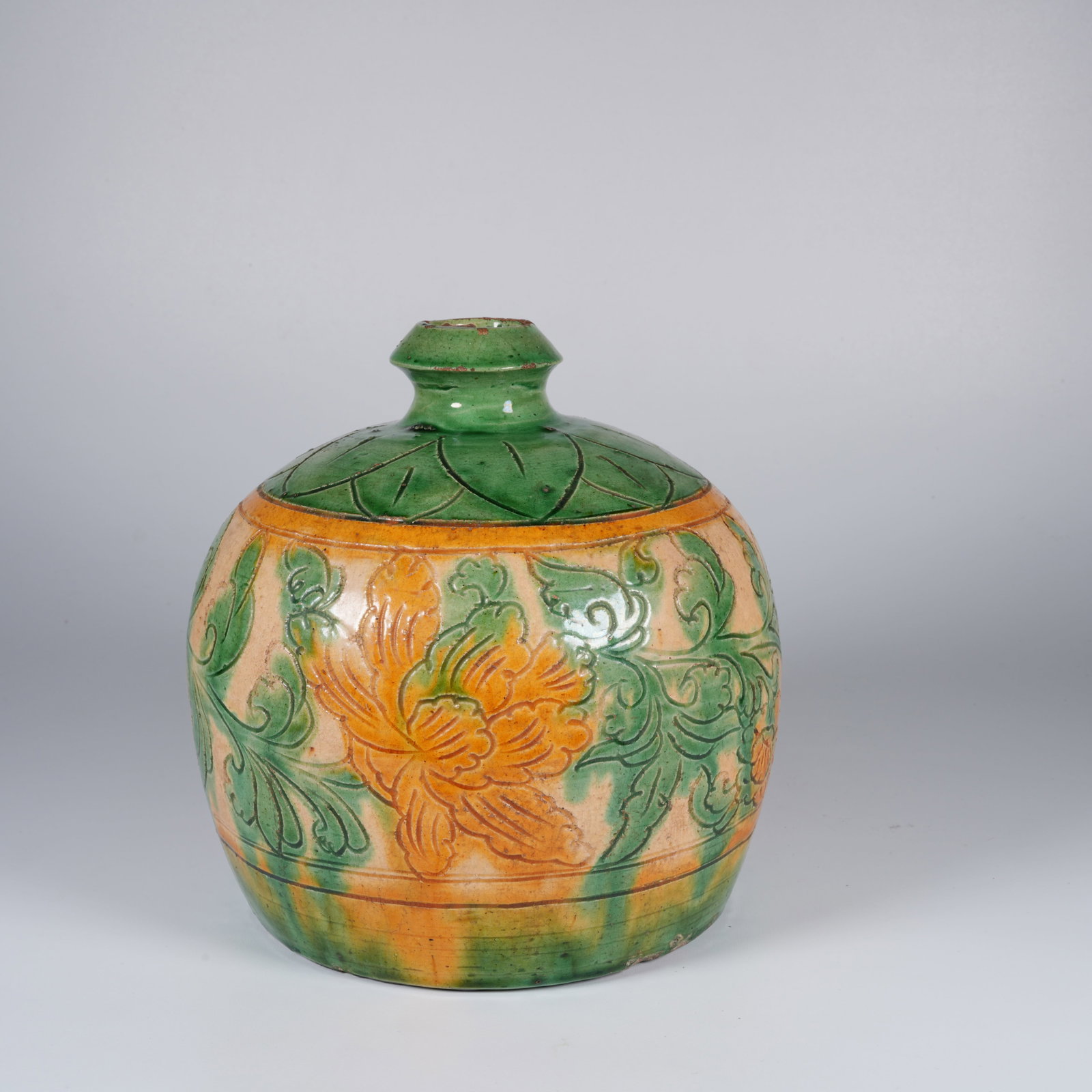 A PLAIN SANCAI JAR WITH FLORAL DESIGN: Plain sancai jar with floral design