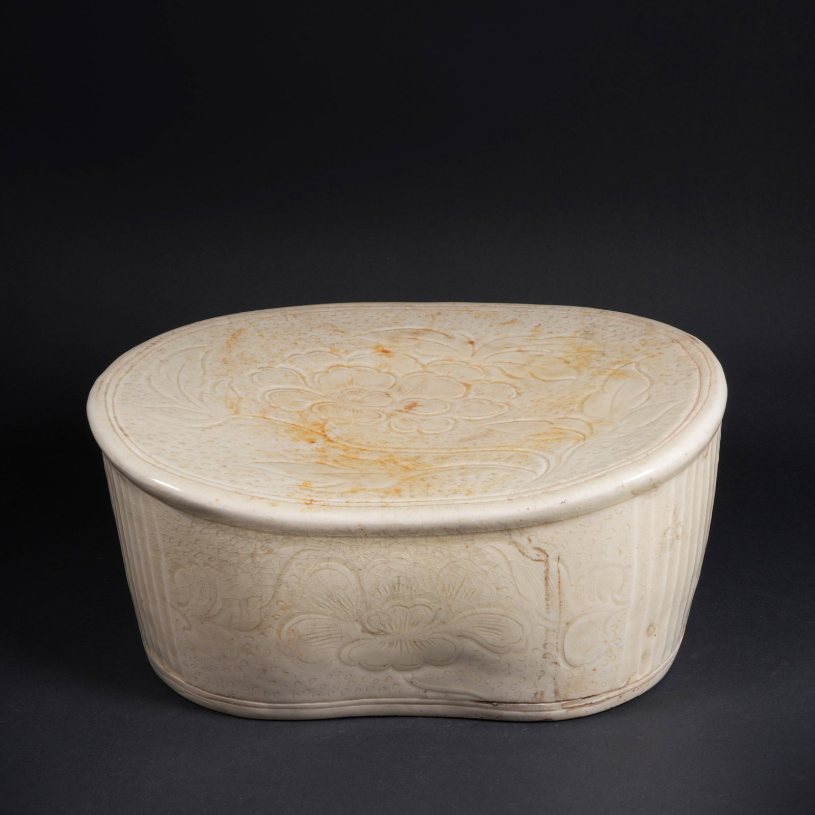 A DING WARE PORCELAIN PILLOW WITH FLORAL MOTIF: Ding ware porcelain pillow with floral motif