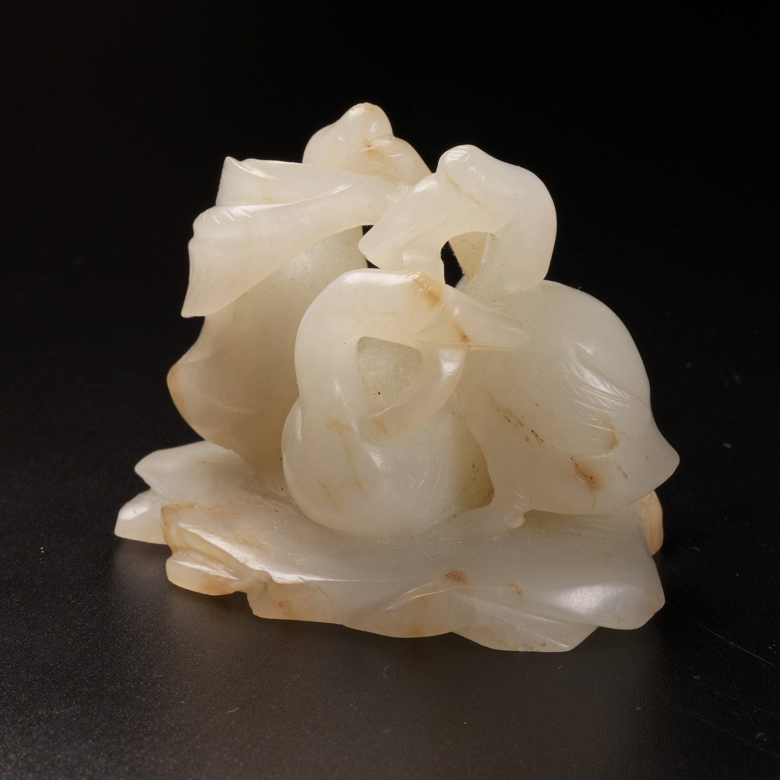A HETIAN JADE THREE GEESE PLAYING ON LEAVES ORNAMENT: Hetian jade three geese playing on leaves ornament