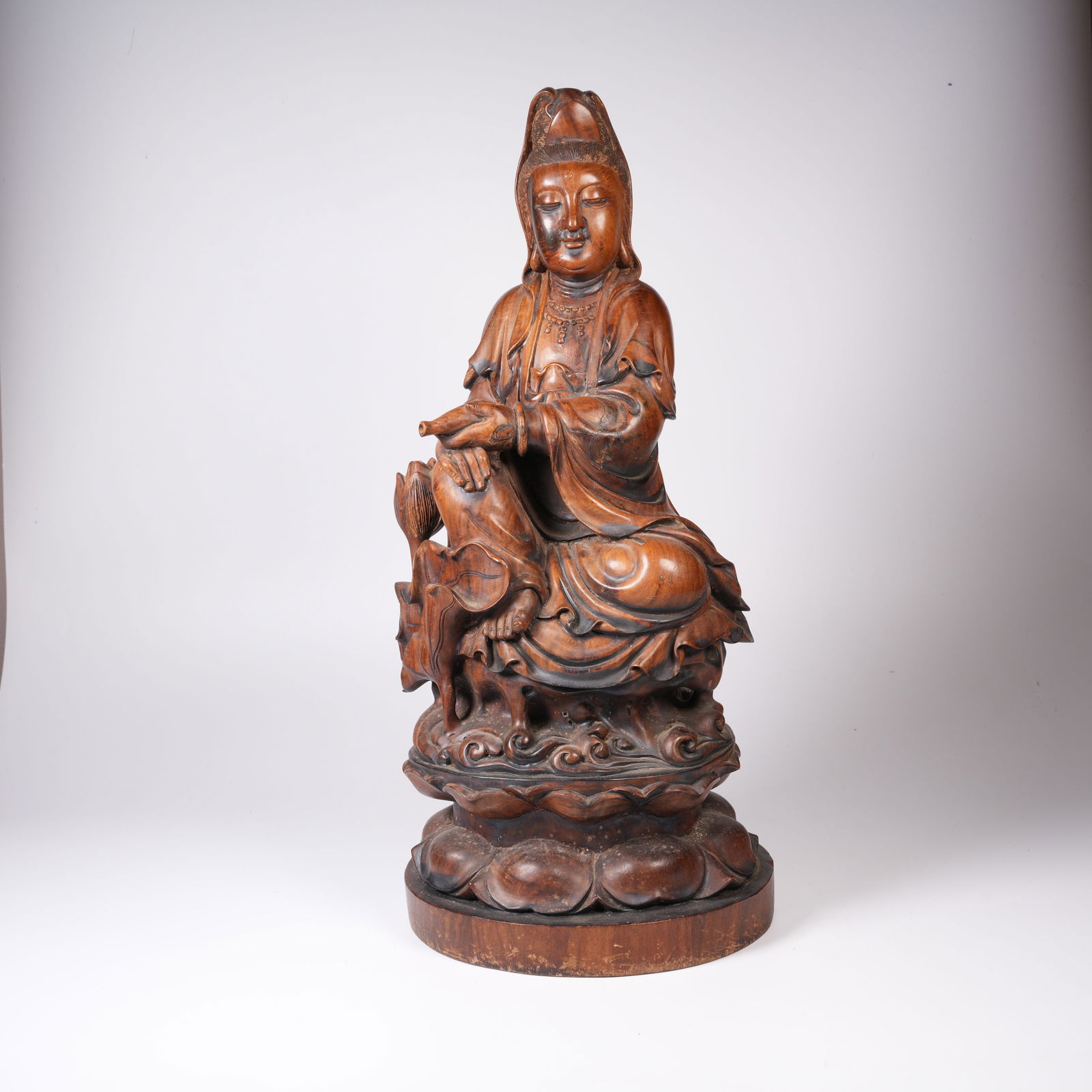 A HUANGHUALI WOOD GUANYIN STATUE IN A CLEAN VASE FORM: Huanghuali wood Guanyin statue in a clean vase form