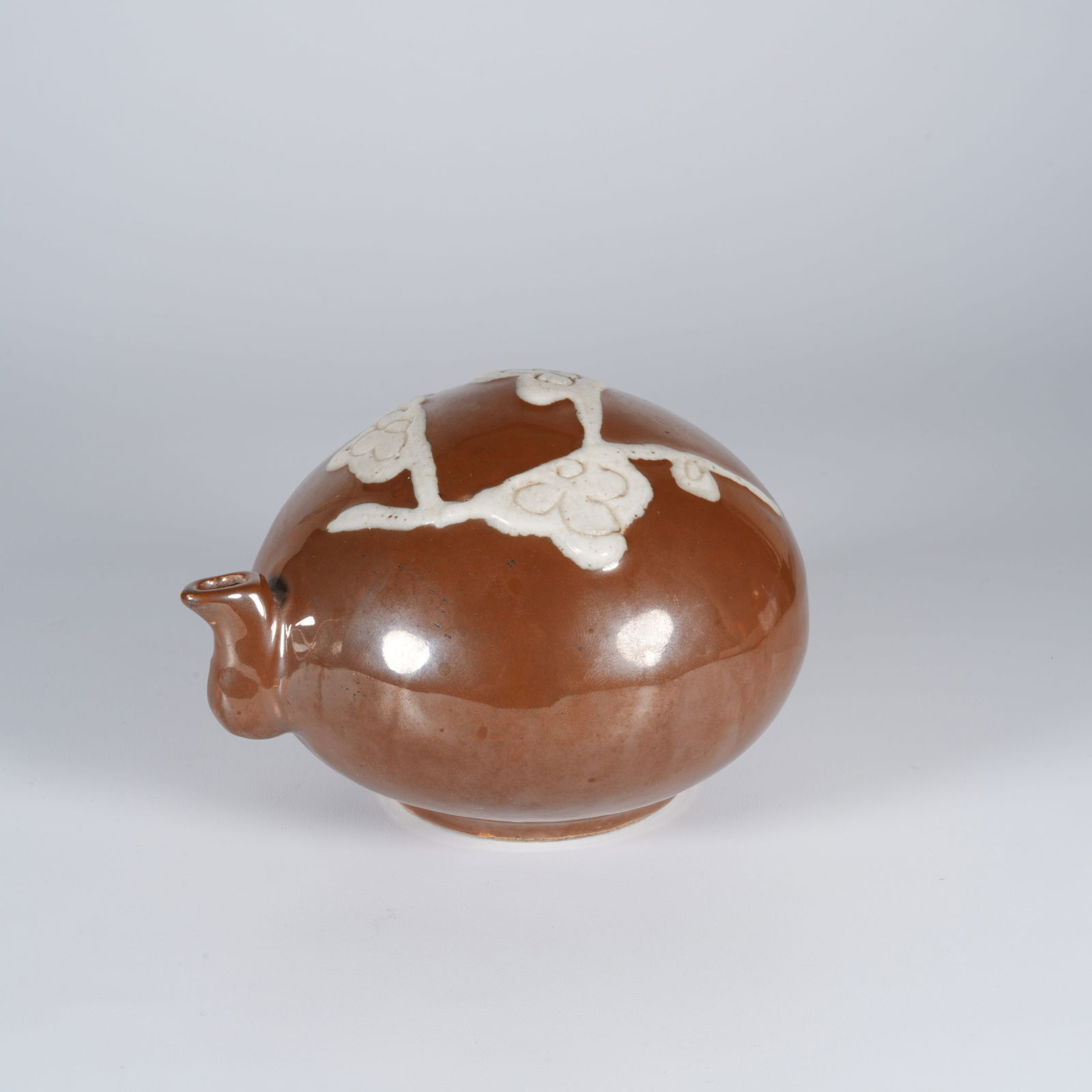 A BROWN-GLAZED INK DROPPER WITH RESERVED PLUM BLOSSOM DESIGN: Brown-glazed ink dropper with reserved plum blossom design