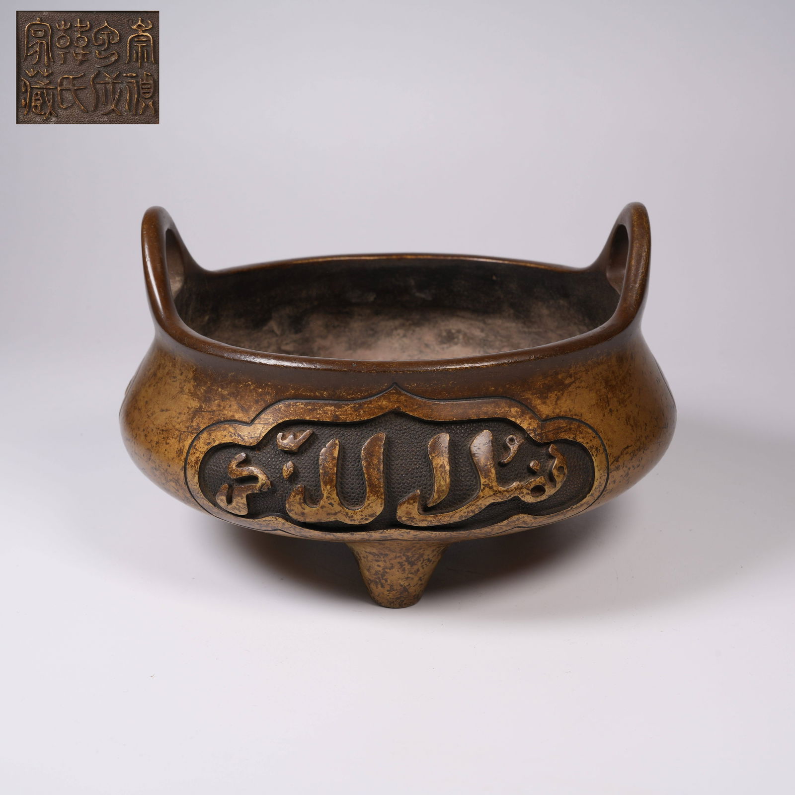 A BRONZE THREE-LEGGED "AWEN" INCENSE BURNER WITH UPWARD-CURVING HANDLES: Bronze three-legged "Awen" incense burner with upward-curving handles