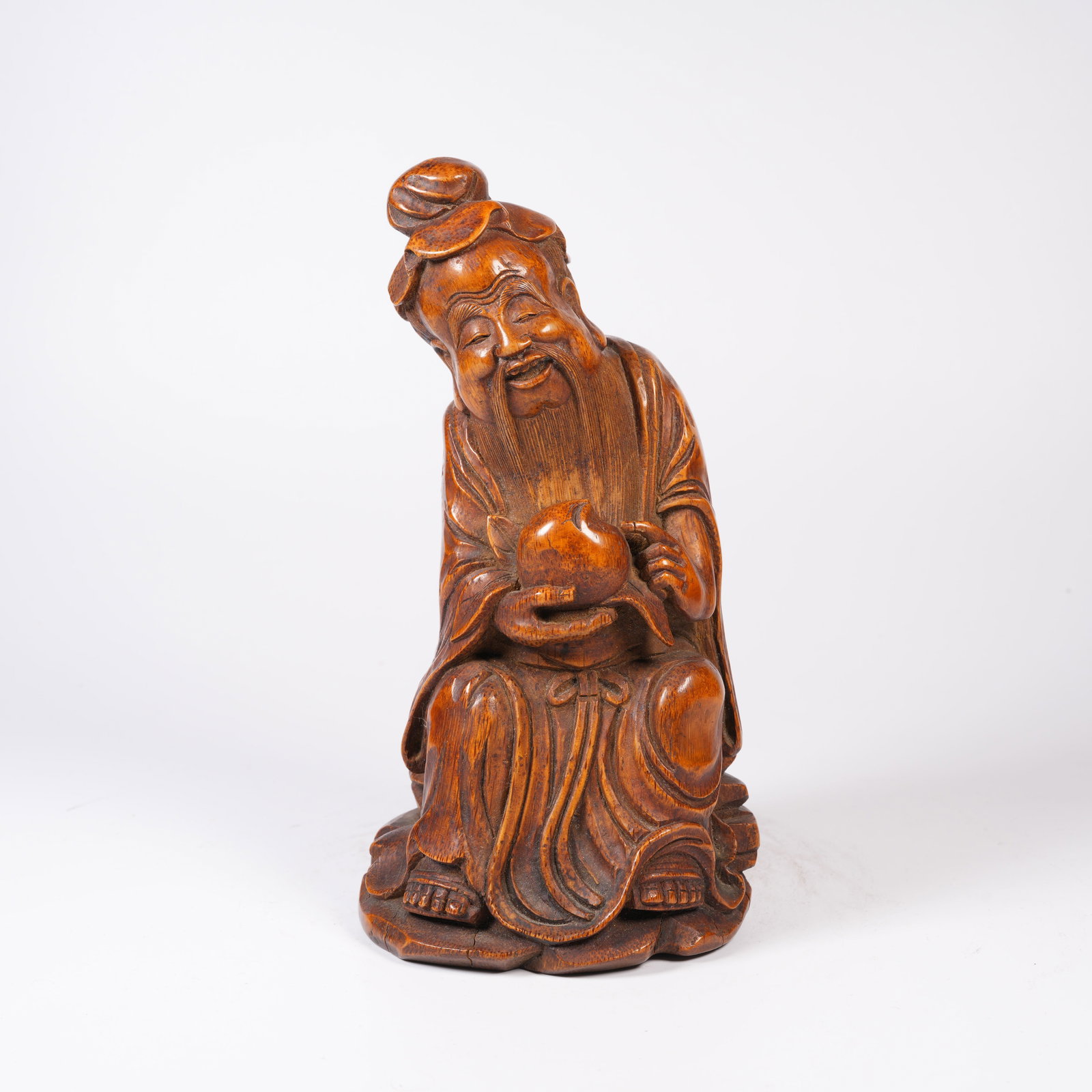 A HUANGHUALI WOOD MINIATURE ORNAMENT OF OLD MAN PRESENTING LONGEVITY: Huanghuali wood miniature ornament of old man presenting longevity