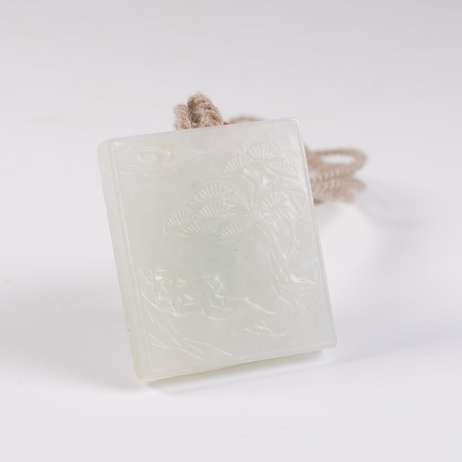 A HETIAN WHITE JADE PENDANT WITH SCHOLAR UNDER PINE MOTIF: Hetian white jade pendant with scholar under pine motif