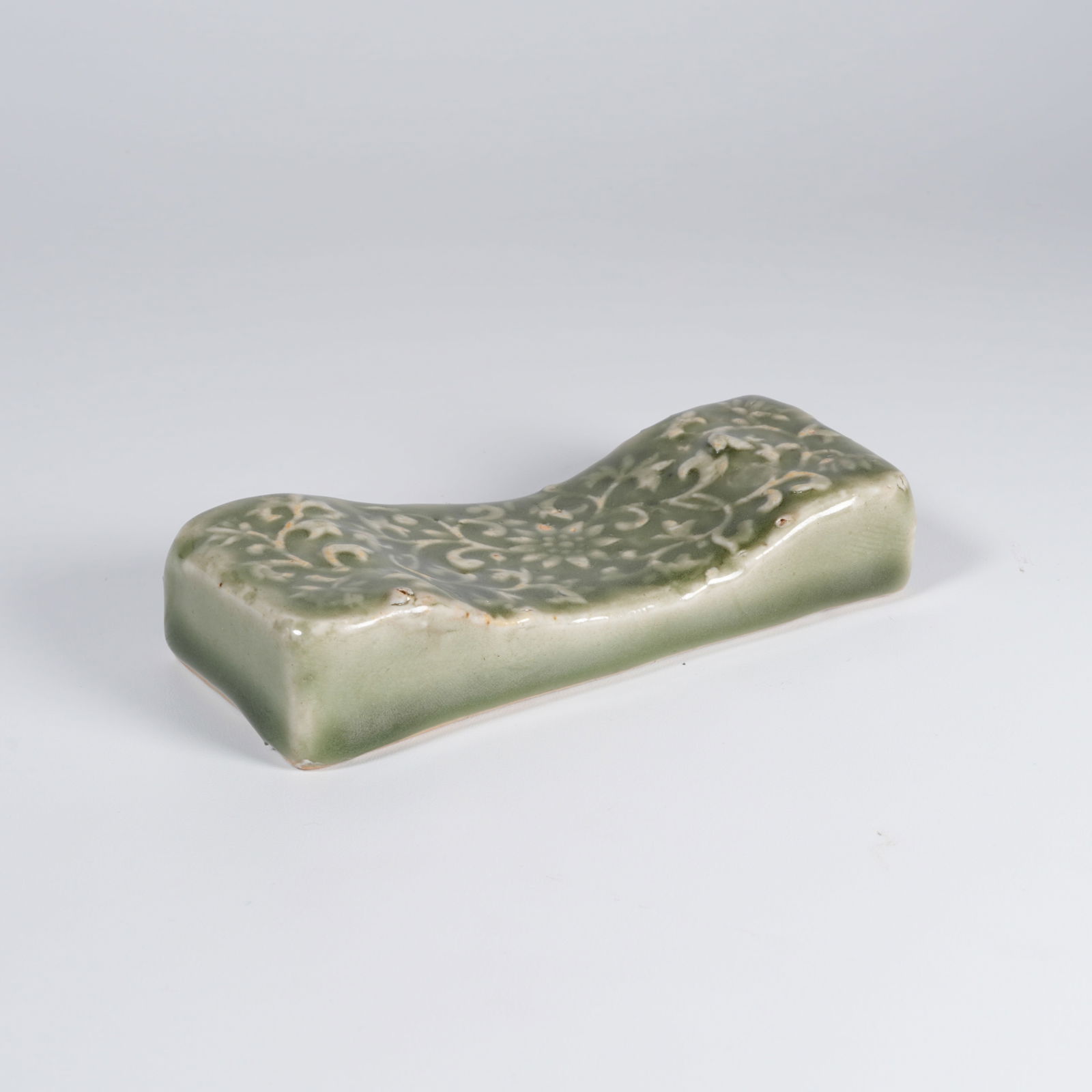 A LONGQUAN WARE FLORAL-PATTERN PILLOW: Longquan ware floral-pattern pillow