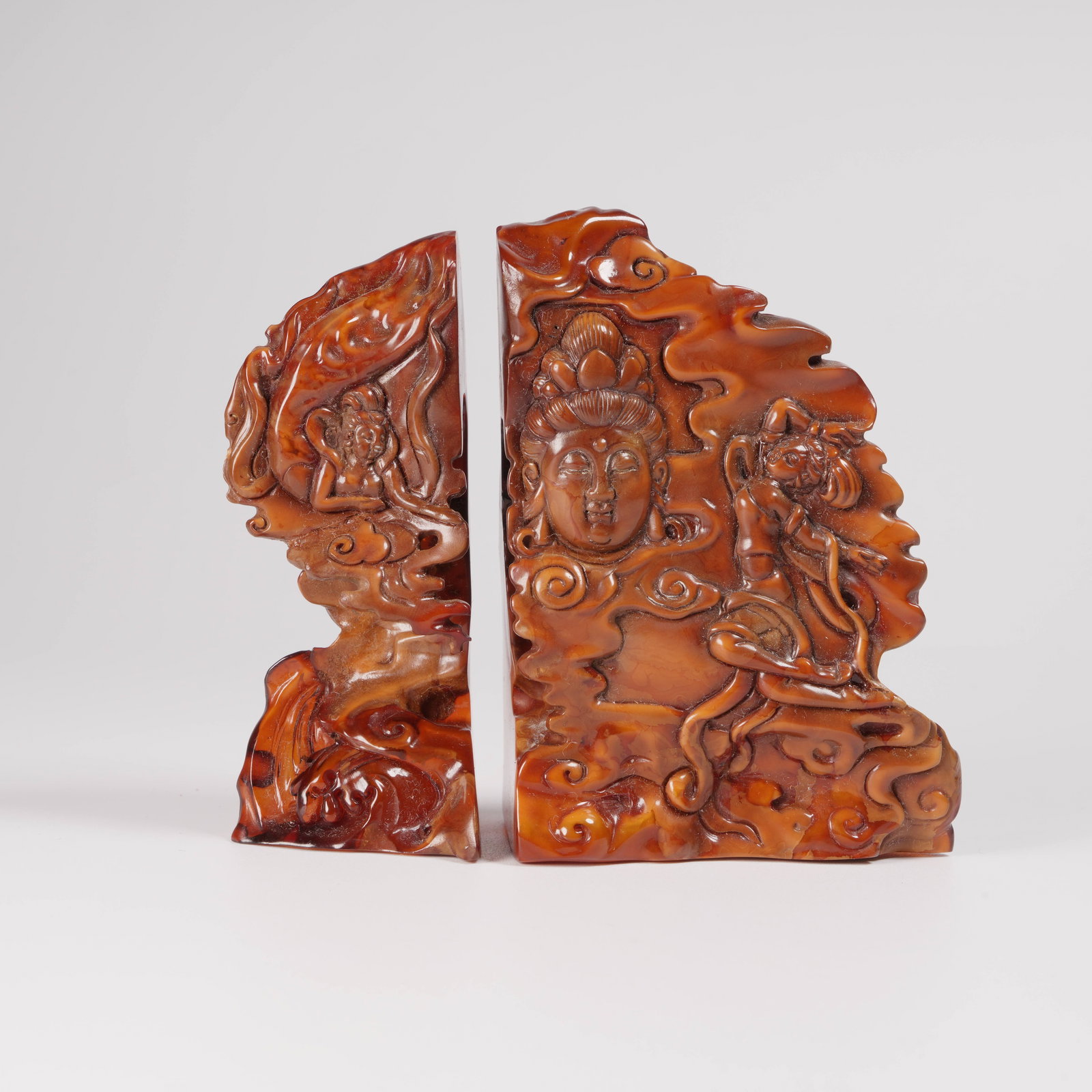 A HONEY-AMBER MOUNTAIN ORNAMENT WITH MOTHER-AND-CHILD STONE AND FLYING-GUANYIN MOTIFS: Honey-amber mountain ornament with mother-and-child stone and flying-Guanyin motifs
