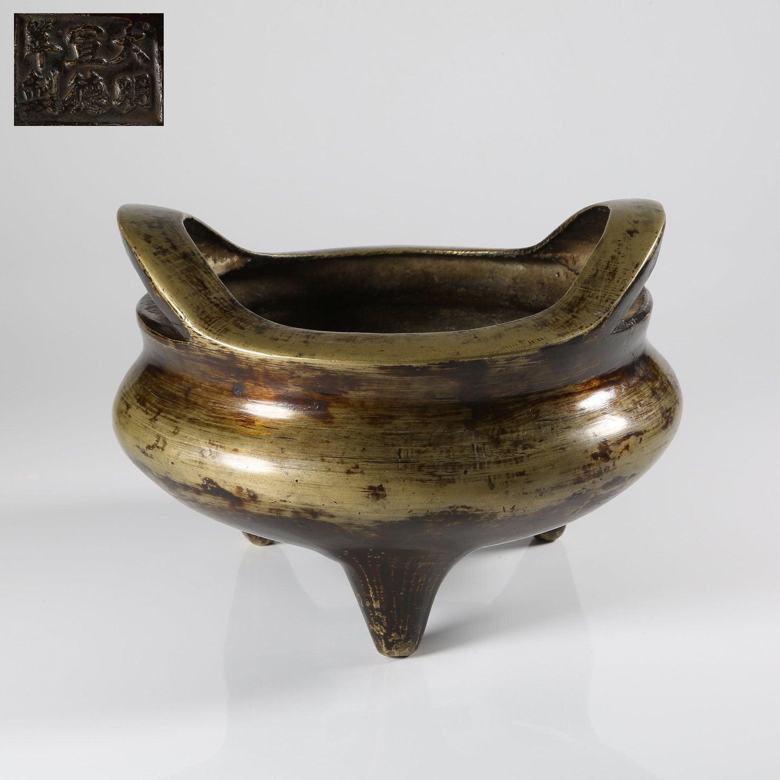 A BRONZE THREE-LEGGED BRIDGE-HANDLED CENSER (1 of 9)