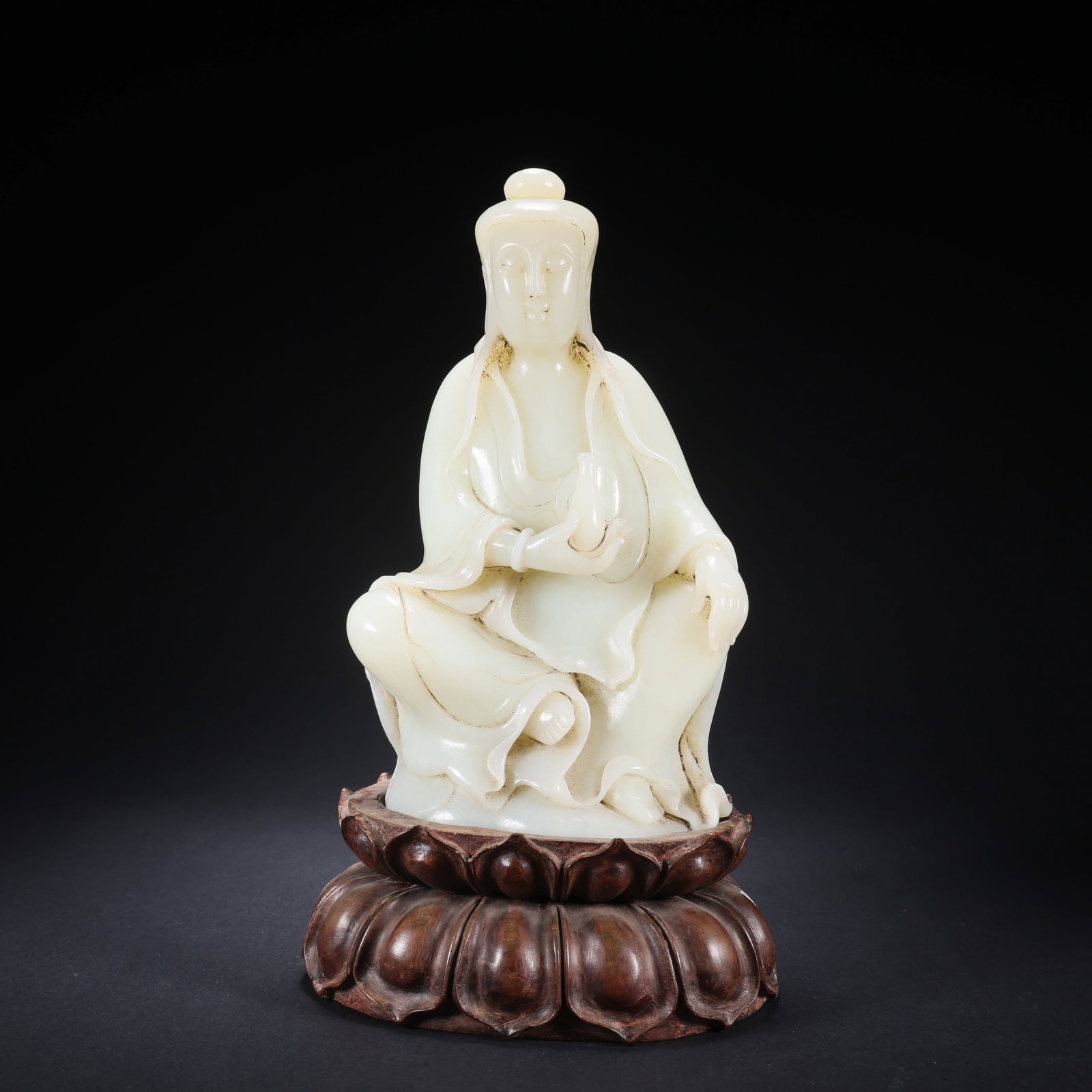 A HETIAN JADE SEATED GUANYIN ON WOODEN BASE HOLDING A VASE (1 of 9)