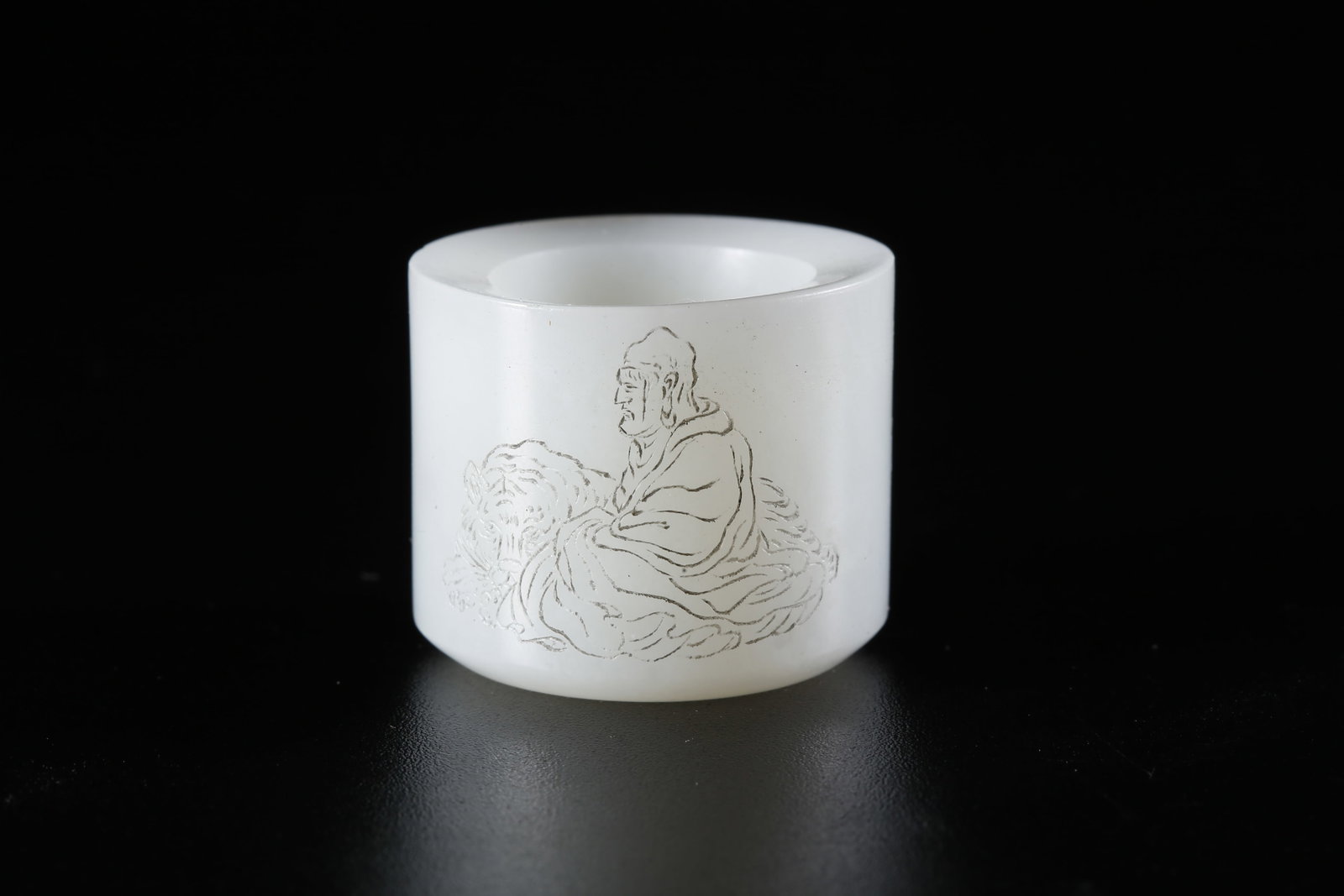 A HETIAN JADE CARVED FINGER RING WITH ARHAT MOTIF: Hetian Jade Carved Finger Ring with Arhat Motif