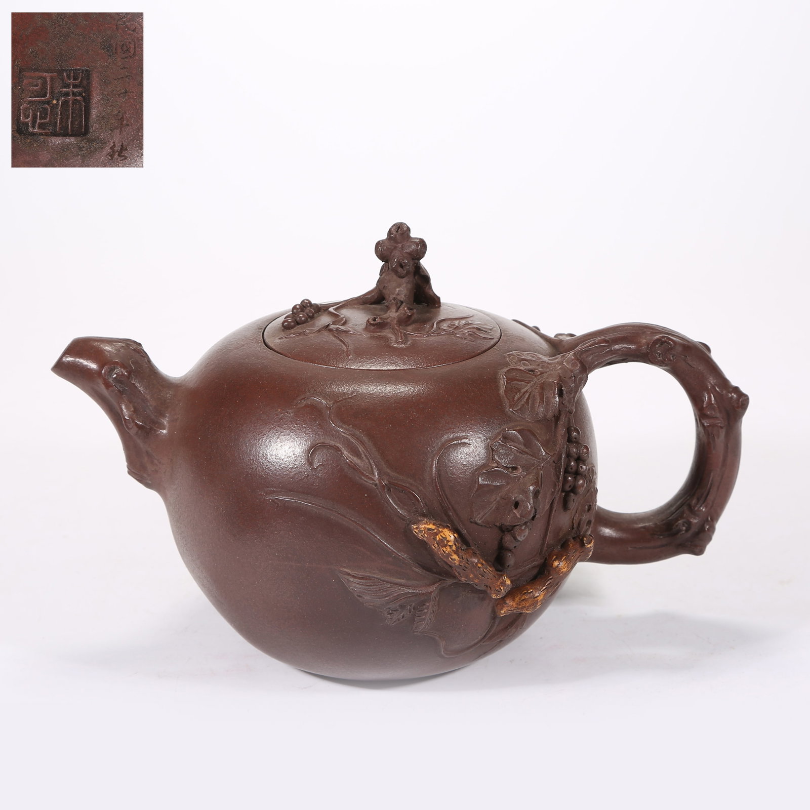 A YIXING (ZISHA) TEAPOT CARVED WITH SQUIRREL AND GRAPE PATTERN: Yixing (zisha) teapot carved with squirrel and grape pattern