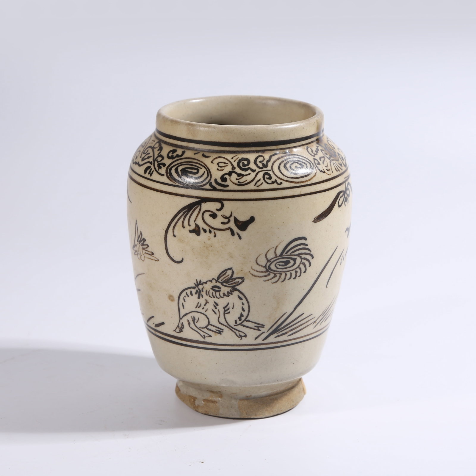 A CIZHOU KILN JAR WITH WHITE BACKGROUND AND BLACK FLOWER-AND-BIRD PATTERN: Cizhou Kiln Jar with White Background and Black Flower-and-Bird Pattern