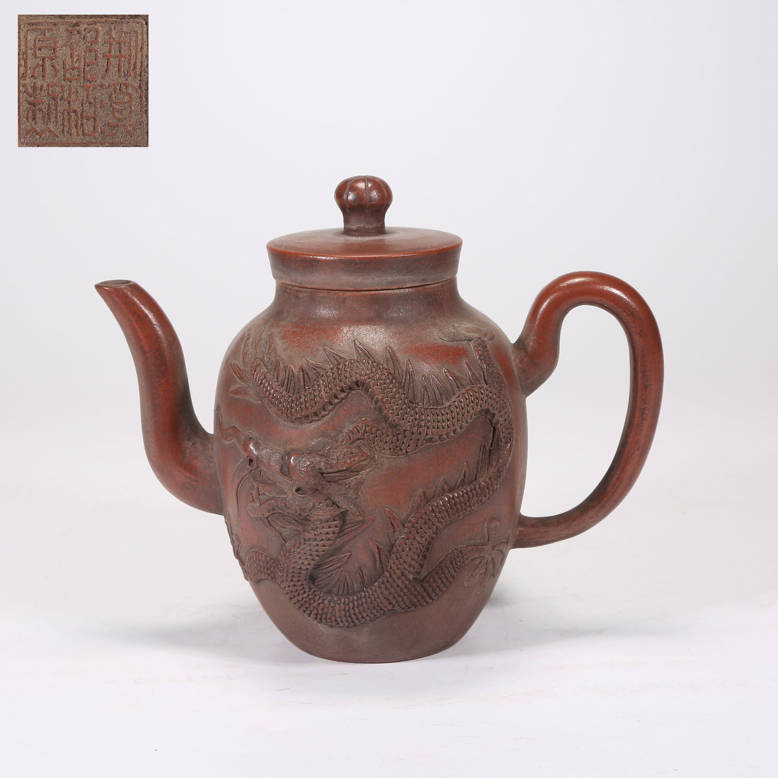 A YIXING (ZISHA) TEAPOT CARVED WITH DRAGON-AND-PHOENIX PATTERN: Yixing (zisha) teapot carved with dragon-and-phoenix pattern