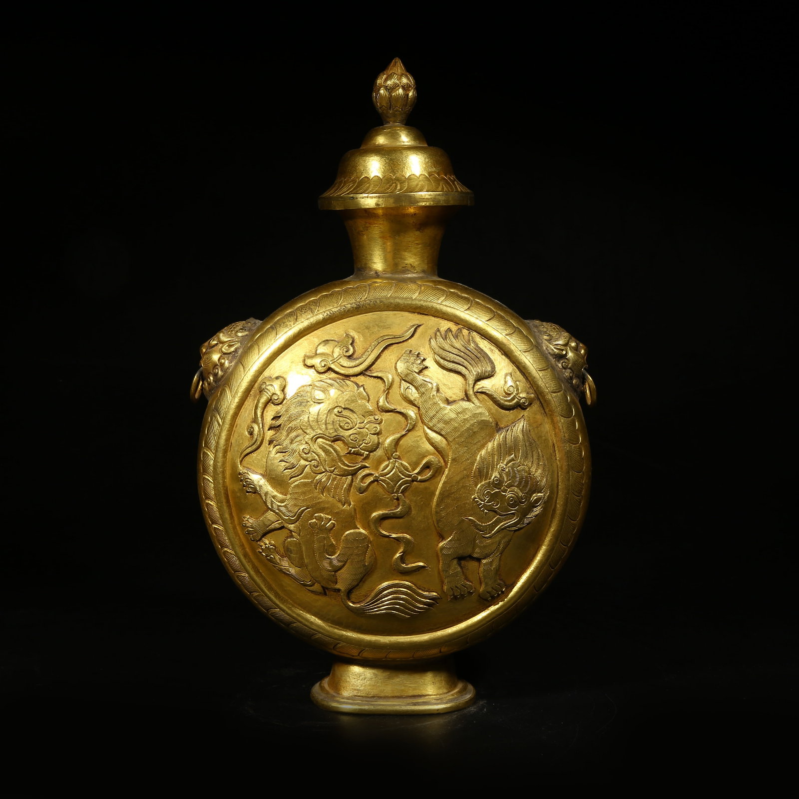 A GILDED BRONZE FLAT BOTTLE WITH LION PLAYING EMBROIDERED BALL MOTIF: Gilded bronze flat bottle with lion playing embroidered ball motif