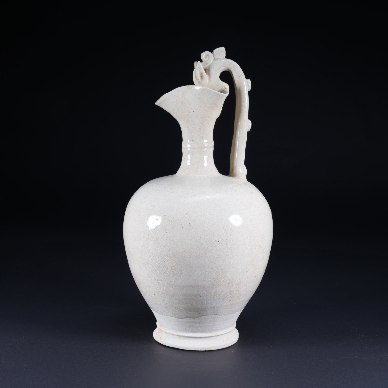 A WHITE-GLAZED EWER WITH DRAGON HANDLE AND FLORAL RIM: White-Glazed Ewer with Dragon Handle and Floral Rim