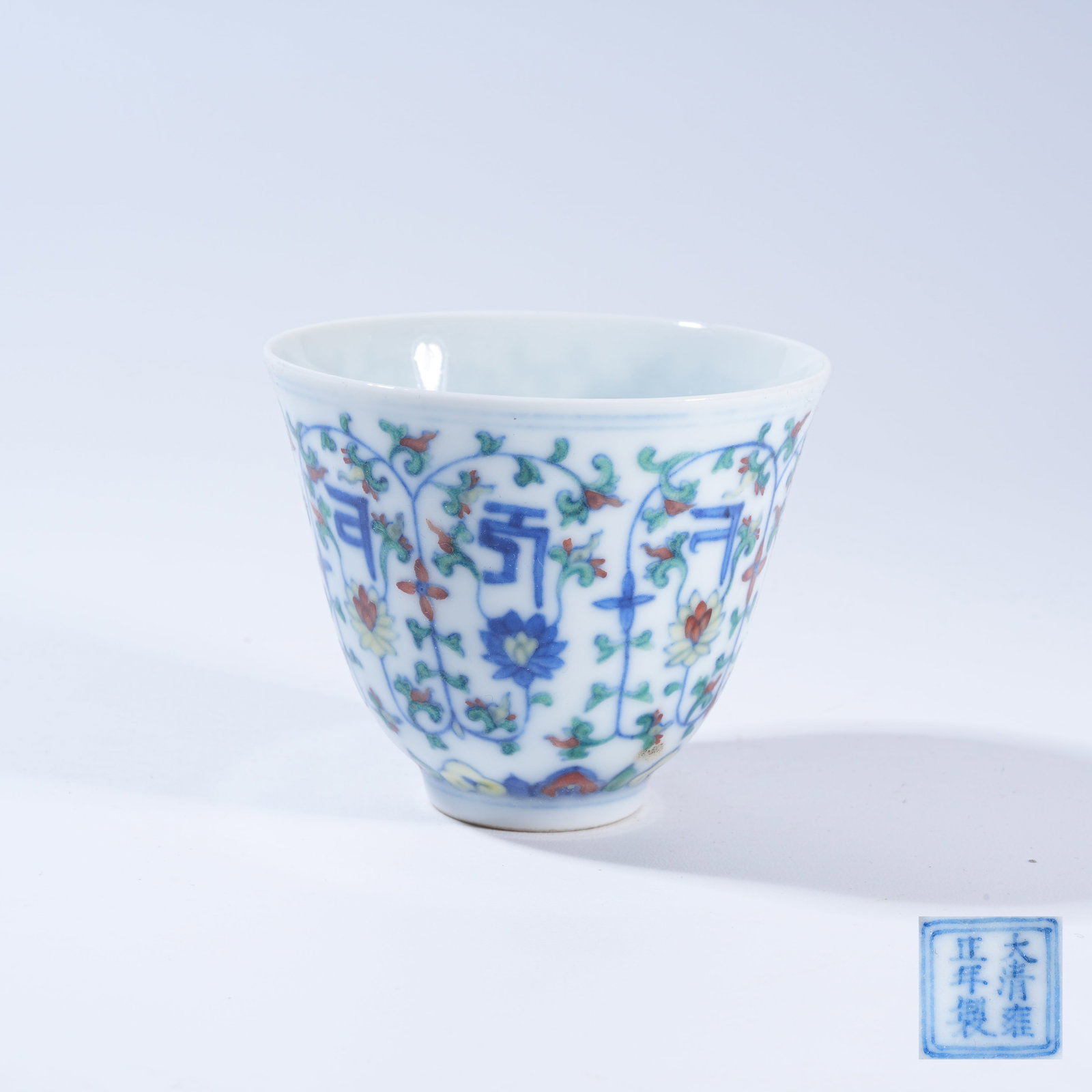 A DOUCAI CUP WITH INTERLACED LOTUS SUPPORTING SANSKRIT CHARACTERS: Doucai Cup with Interlaced Lotus Supporting Sanskrit Characters