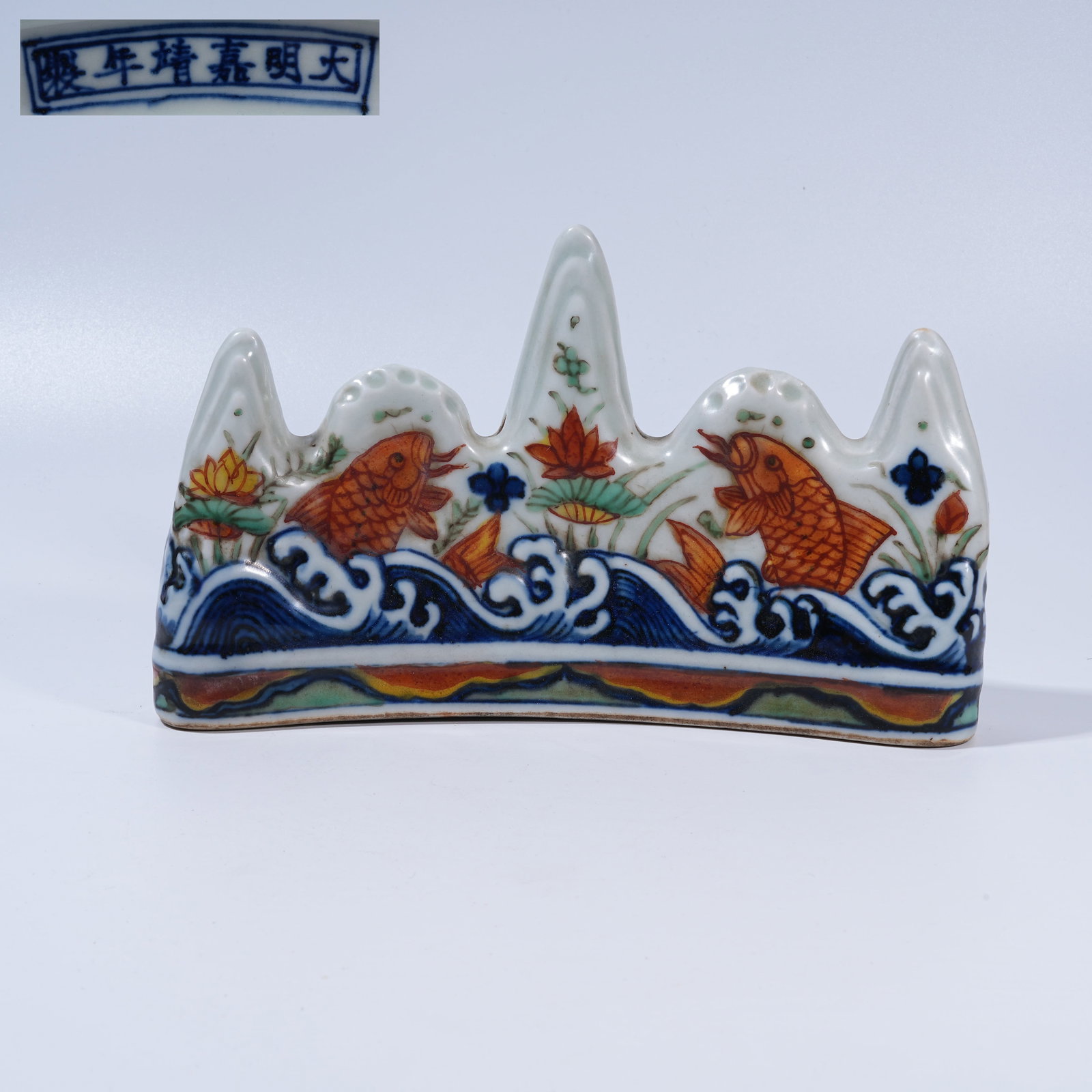 A BLUE-AND-WHITE AND IRON-RED BRUSH REST WITH CARP MOTIF IN LANDSCAPE FORM: Blue-and-White and Iron-Red Brush Rest with Carp Motif in Landscape Form