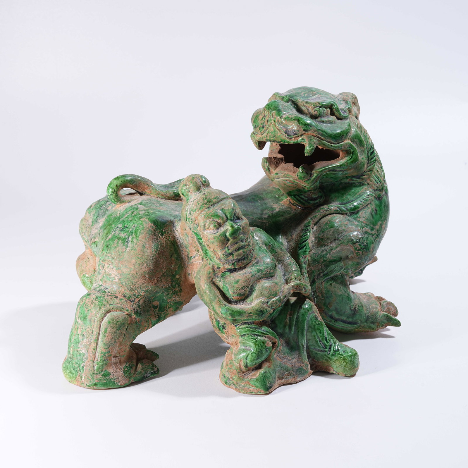 A GREEN-GLAZED FIGURINE OF A MAN TAMING A LION: Green-Glazed Figurine of a Man Taming a Lion