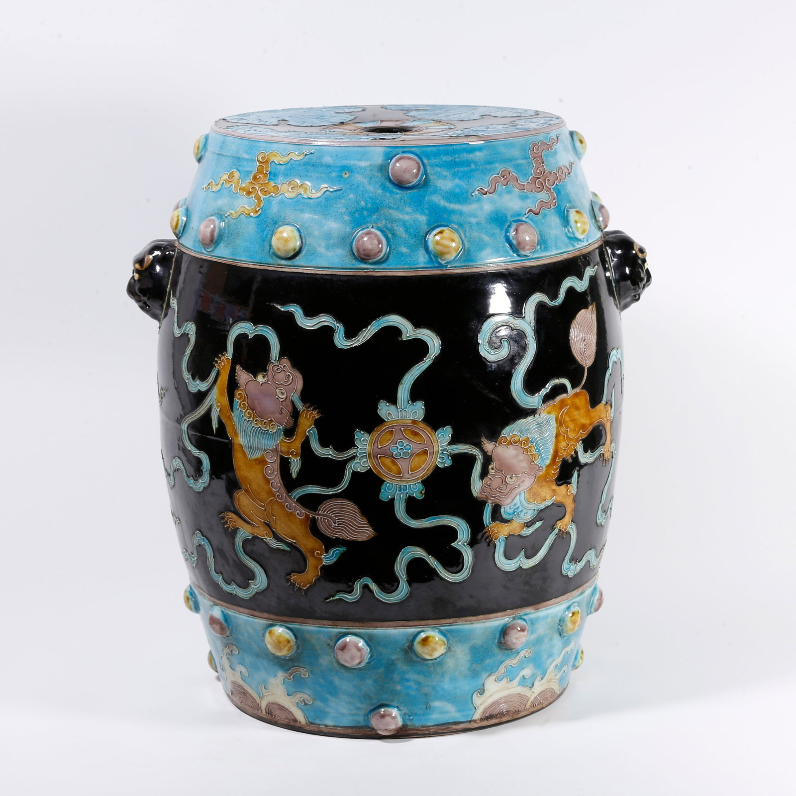 A FAHUA GLAZED DRUM STOOL WITH LION PLAYING WITH SILK BALL PATTERN: Fahua Glazed Drum Stool with Lion Playing with Silk Ball Pattern