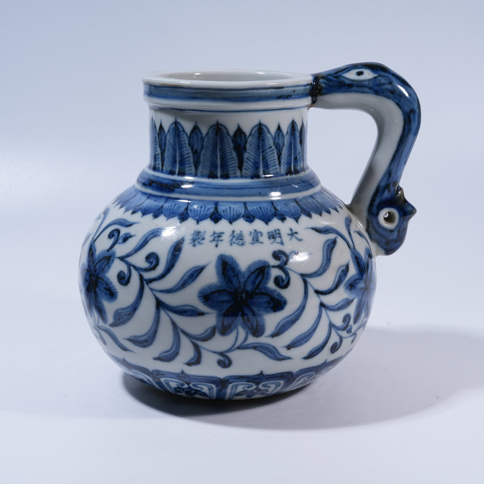 A BLUE-AND-WHITE EWER WITH FLORAL MOTIFS AND DRAGON HANDLE: Blue-and-White Ewer with Floral Motifs and Dragon Handle