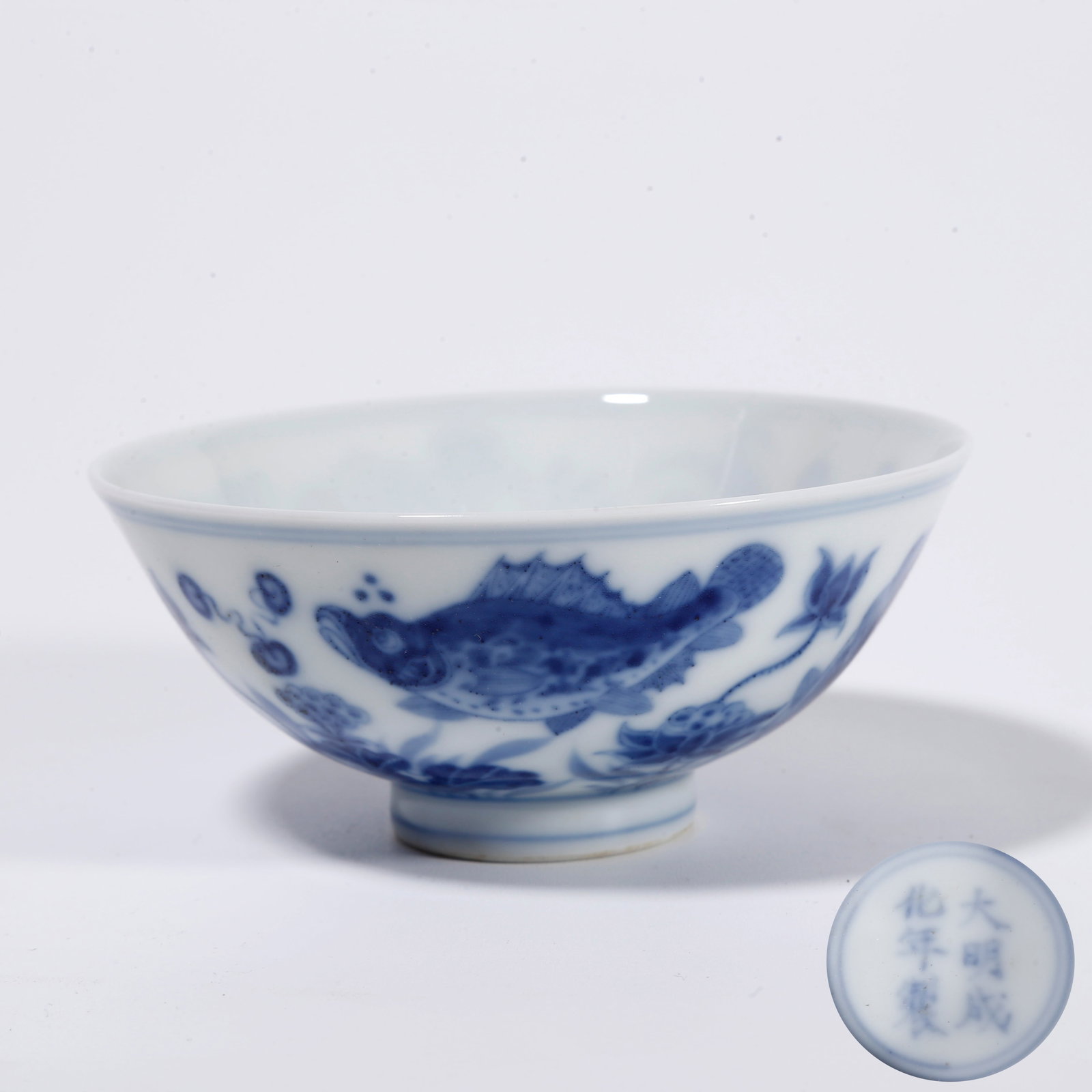 A BLUE AND WHITE CUP WITH FISH AND ALGAE PATTERN: Blue and White Cup with Fish and Algae Pattern
