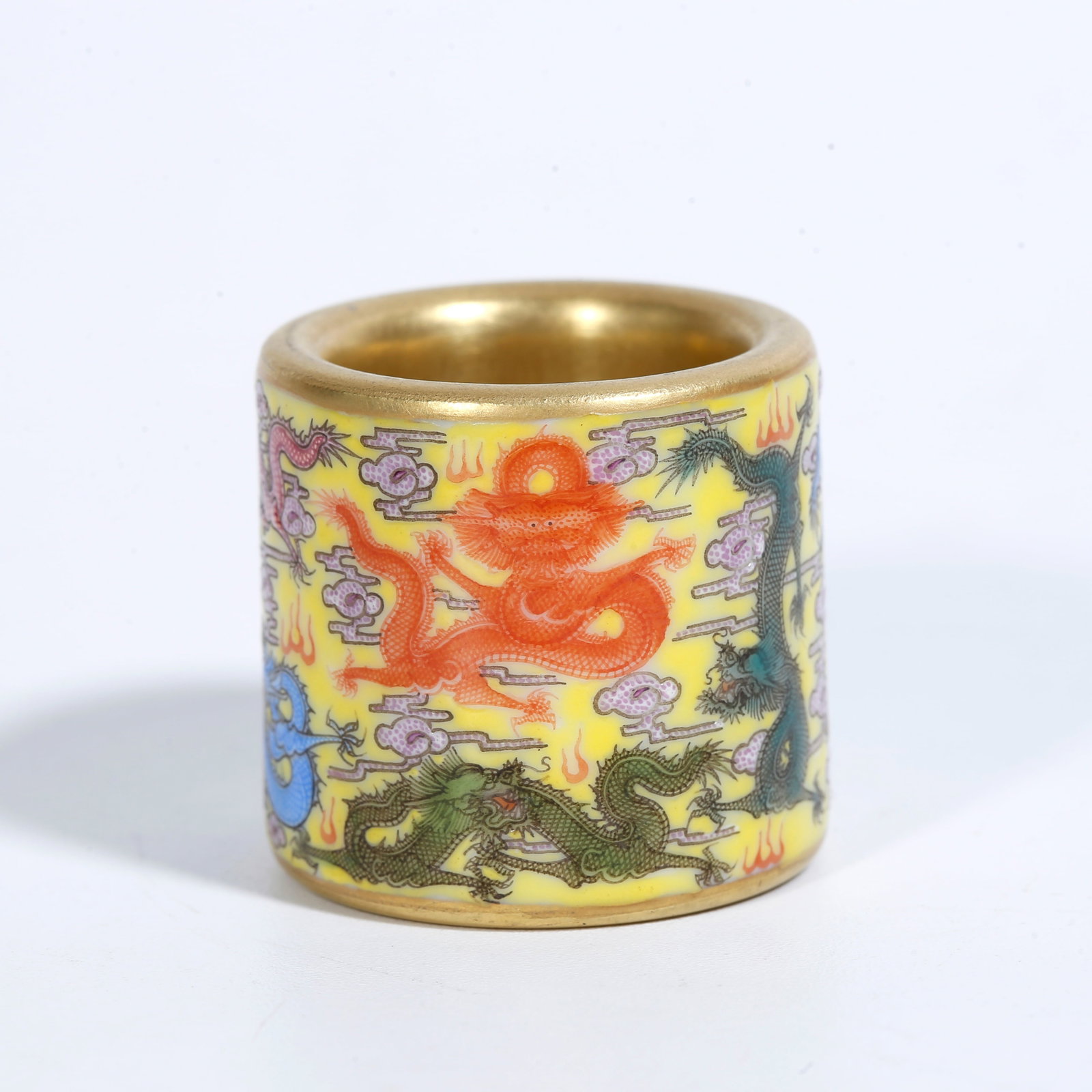 A YELLOW-GROUND FAMILLE-ROSE THUMB RING WITH NINE DRAGONS MOTIF: Yellow-Ground Famille-Rose Thumb Ring with Nine Dragons Motif