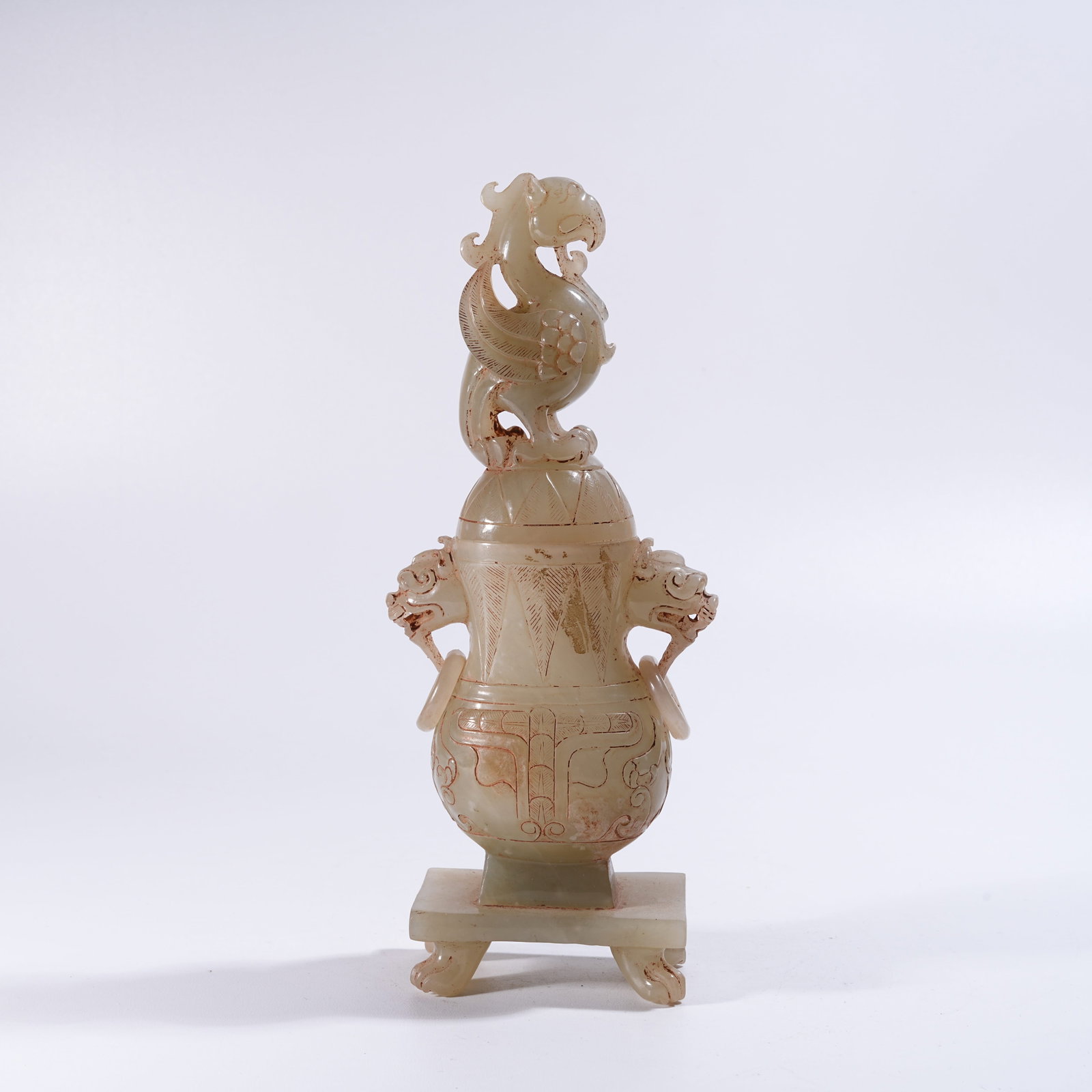 A ARCHAIC JADE COVERED BOTTLE WITH PHOENIX-HEAD FINIAL: Archaic Jade Covered Bottle with Phoenix-Head Finial