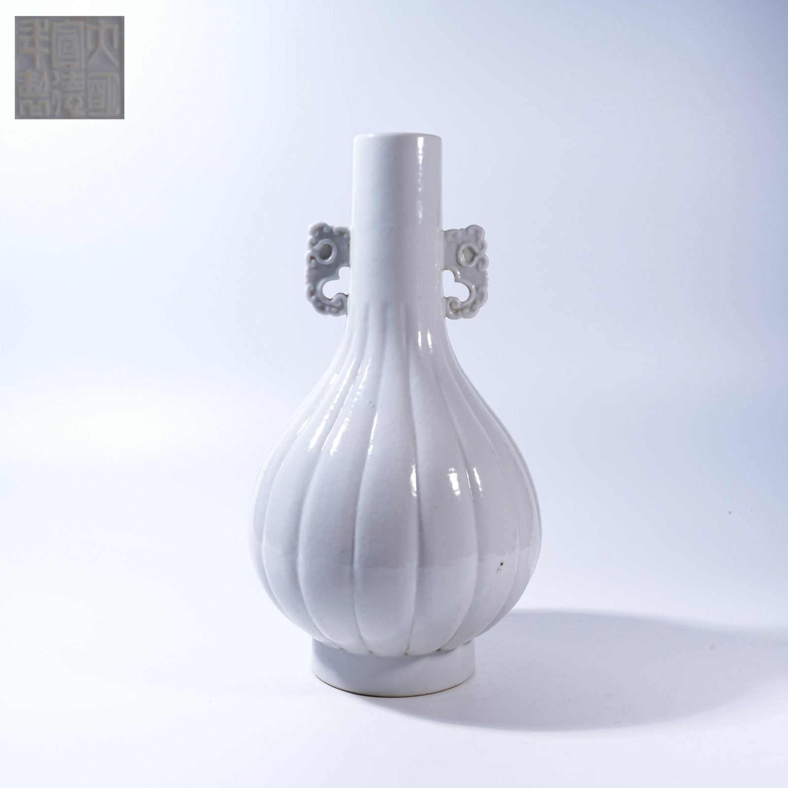 A WHITE-GLAZED MELON-RIBBED VASE WITH ELEPHANT-HEAD HANDLES (1 of 9)