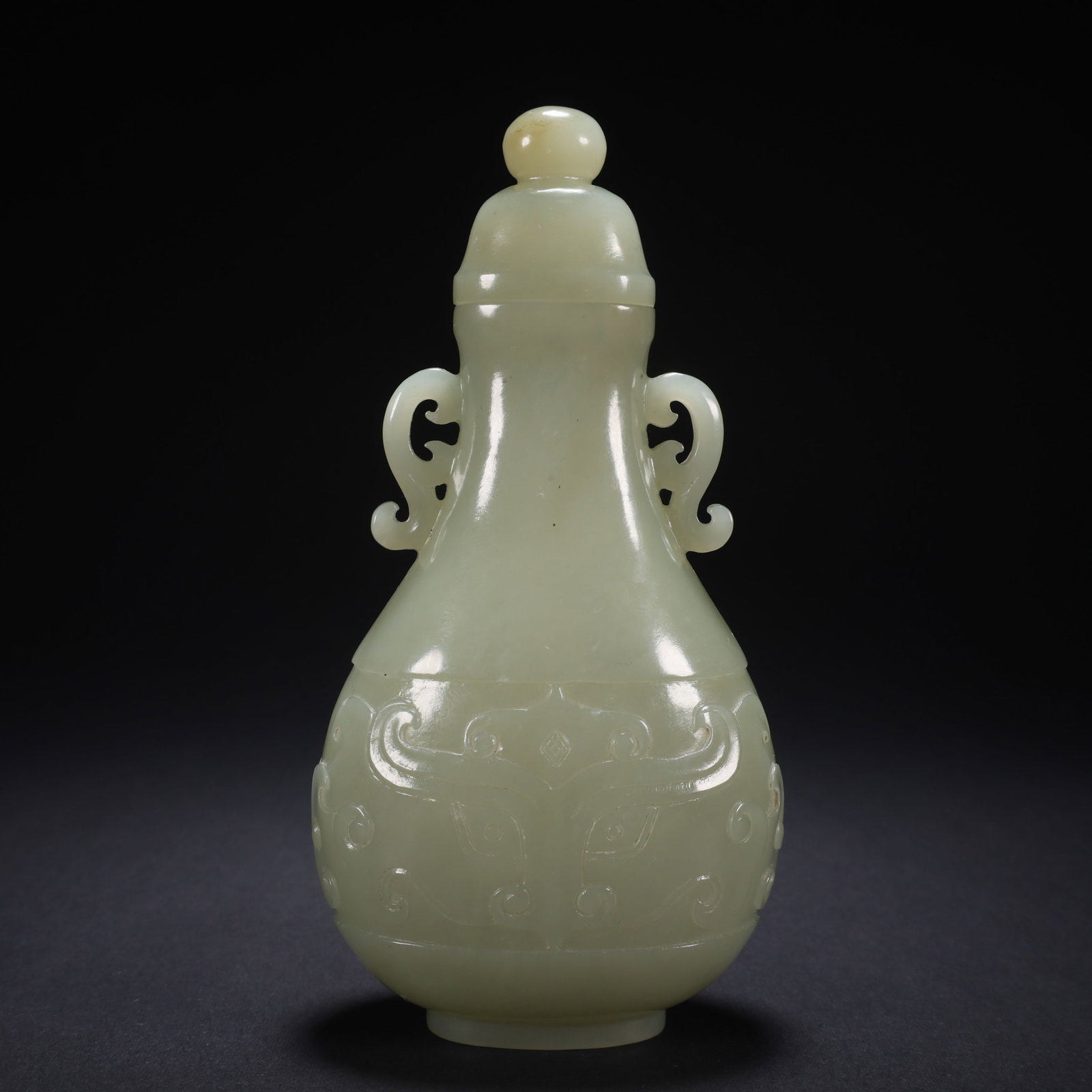 A HETIAN JADE BEAST-FACE PATTERN DOUBLE-HANDLED COVERED BOTTLE: Hetian Jade Beast-Face Pattern Double-Handled Covered Bottle