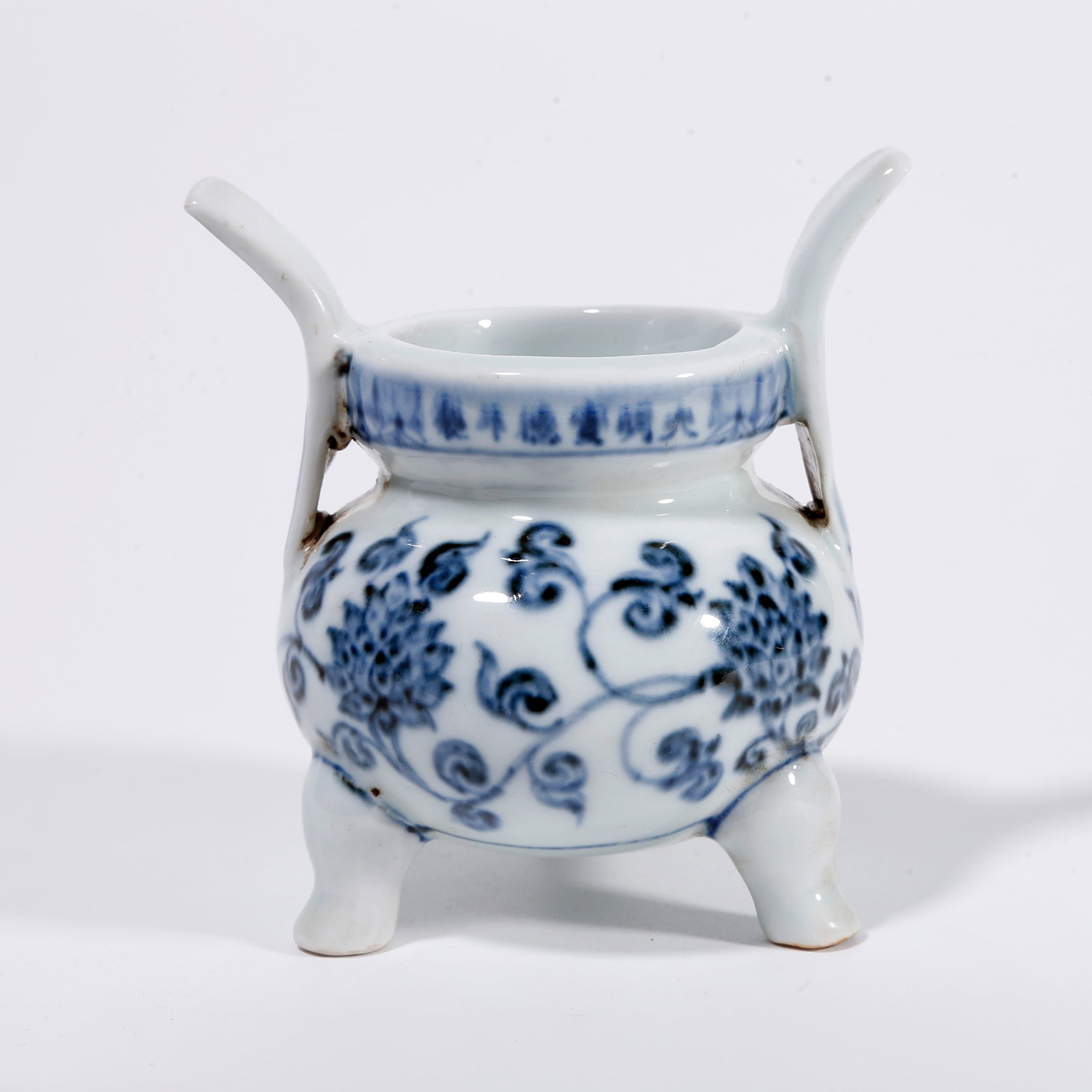 A BLUE AND WHITE TRIPOD CENSER WITH INTERLOCKING FLORAL PATTERN: Blue and White Tripod Censer with Interlocking Floral Pattern